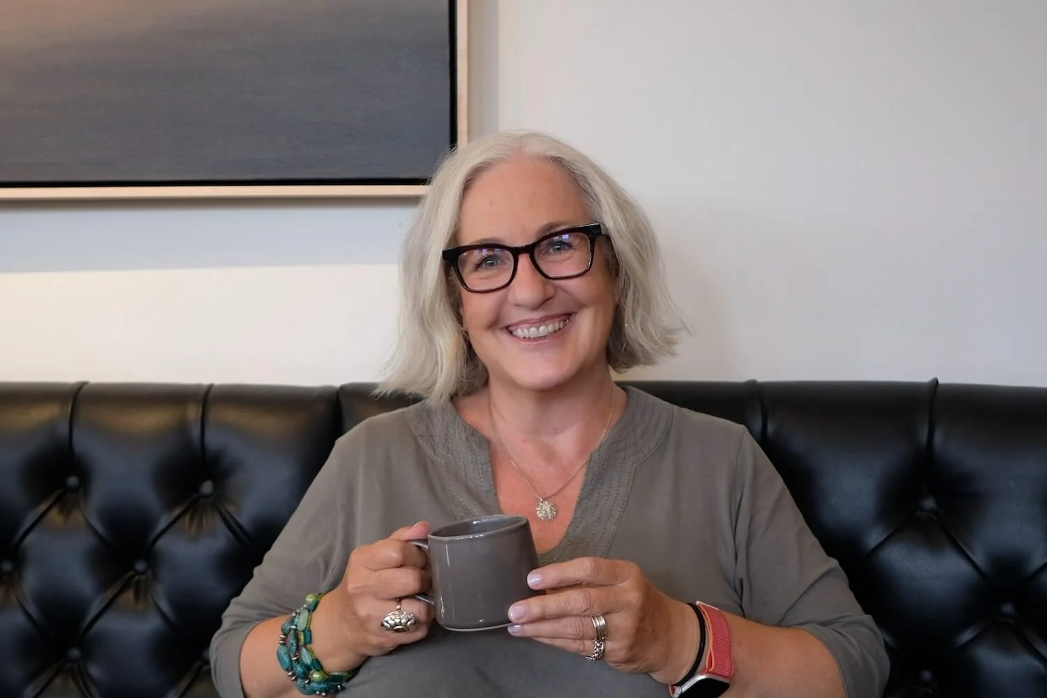 Kerstin Martin at a Coffee Shop smiling and holding a cup of coffee