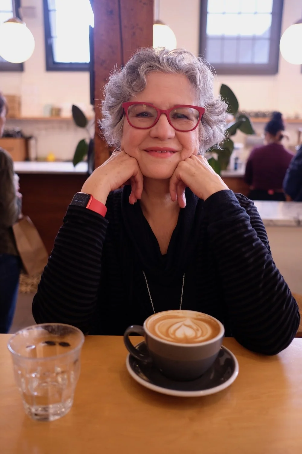 Musician Valerie Day in a Coffee Shop wirth a cup of coffee and glass of water