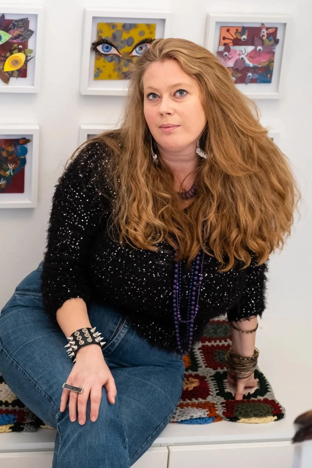 Artist Elinor Trier in front of a studio wall with her paintings