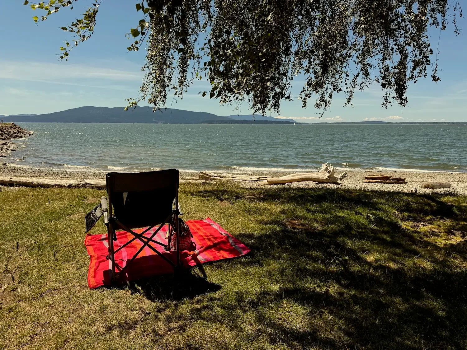 Photo of a picnic chair looking out at the ocean and islands at Marine Park in Bellingham, WA