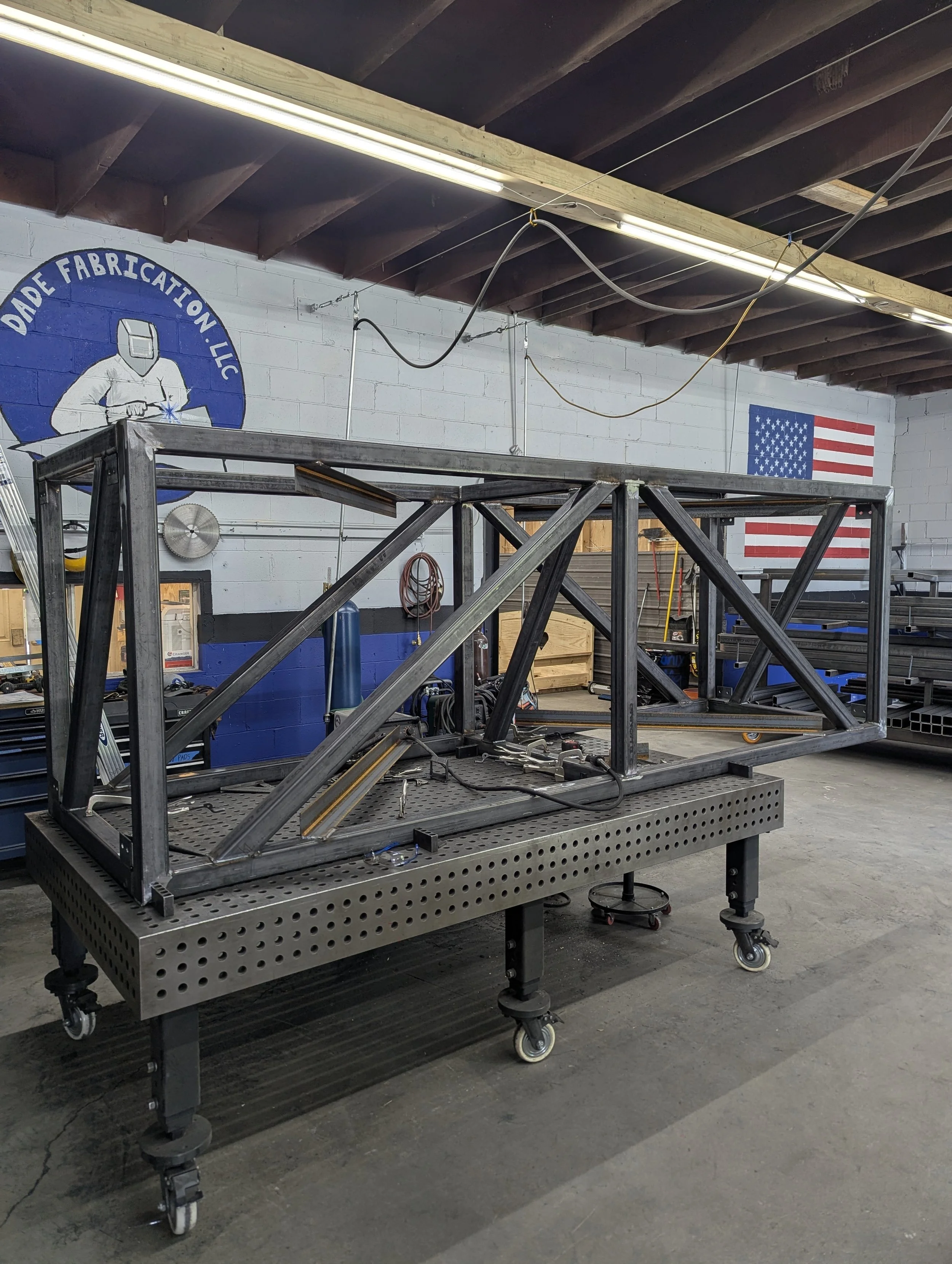 Welded structural steel frame on the fixture table at Dade Fabrication