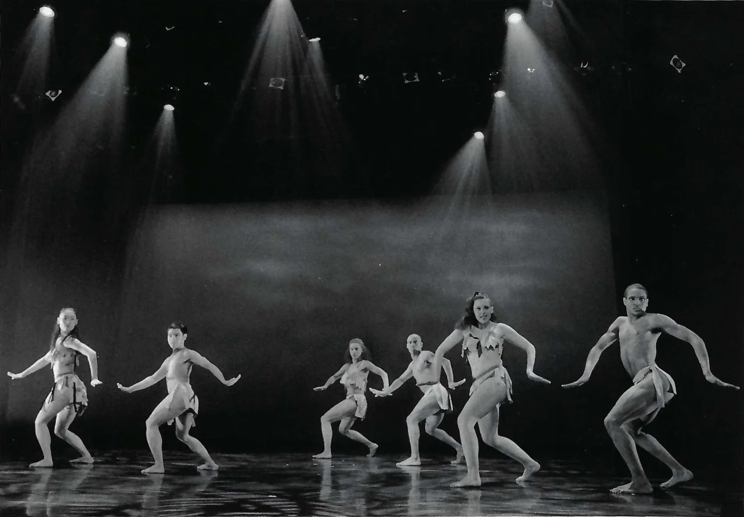 Dancers on stage under spotlights