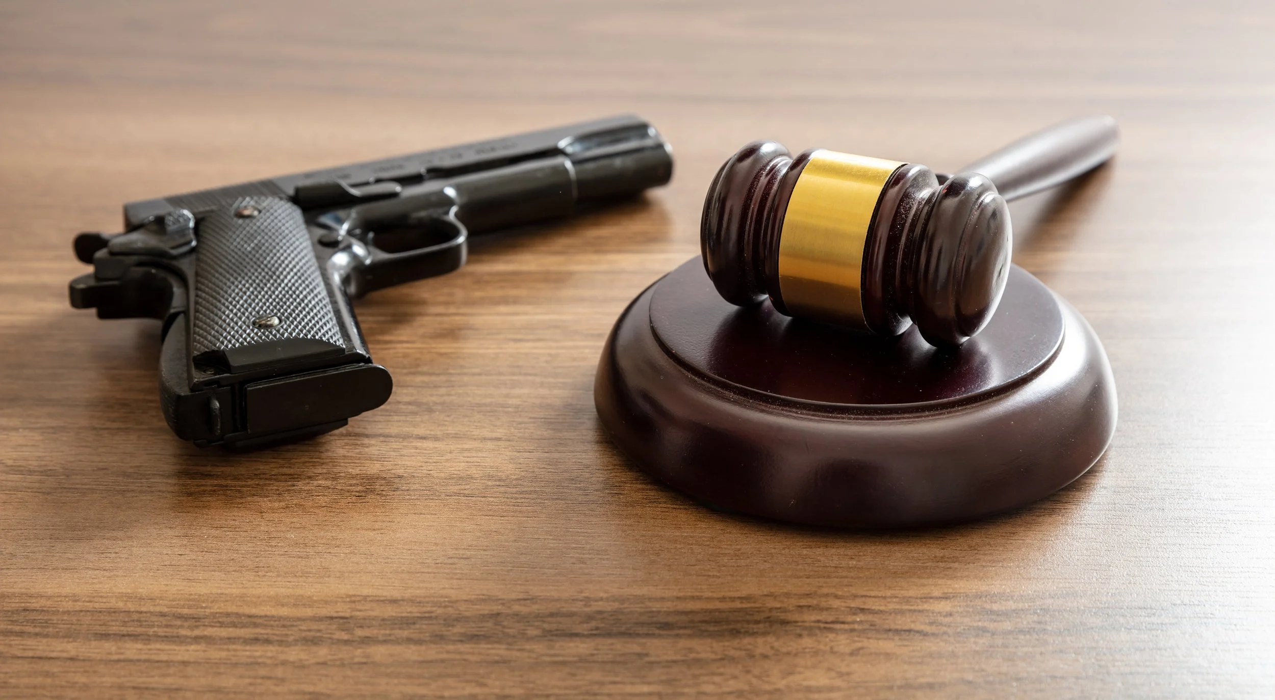 Gun and gavel on a desk implying a violent crime has occurred