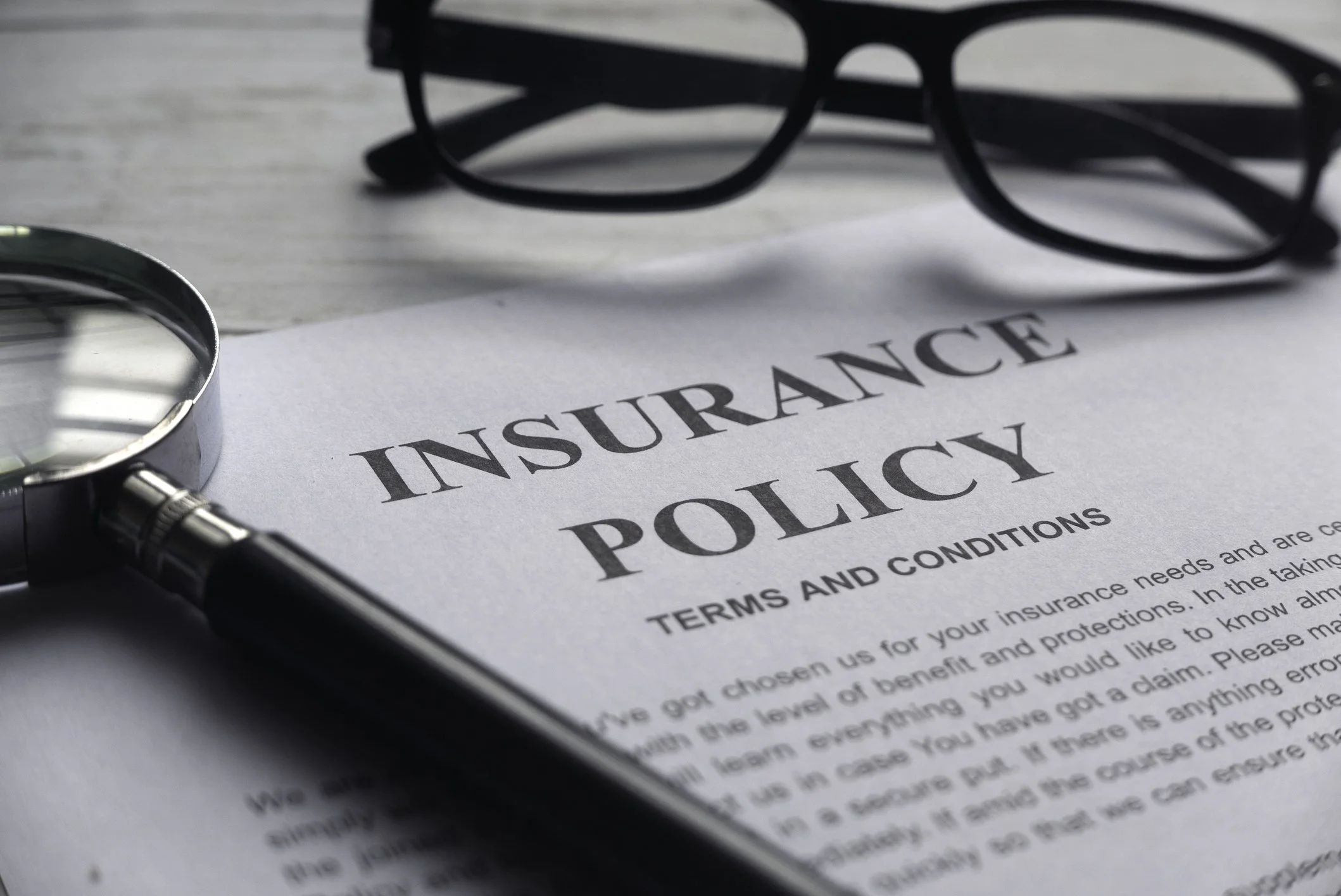 Insurance policy term and conditions document with glasses at the top