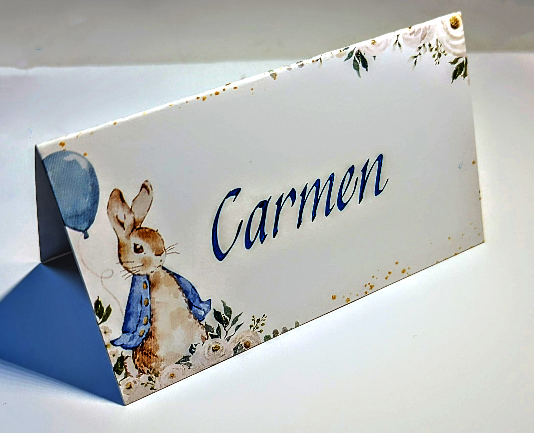 tented place card with watercolored Peter Rabbit image, hand lettered in Italic calligraphy in blue ink.
