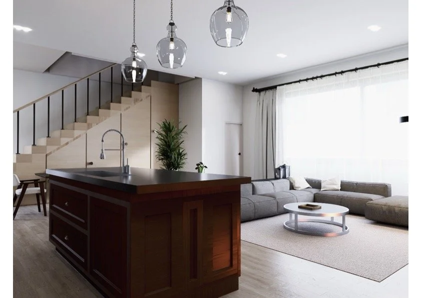 Modern living room with a kitchen island, hanging glass pendant lights, a staircase, a gray sectional sofa, a coffee table, and large windows with curtains.