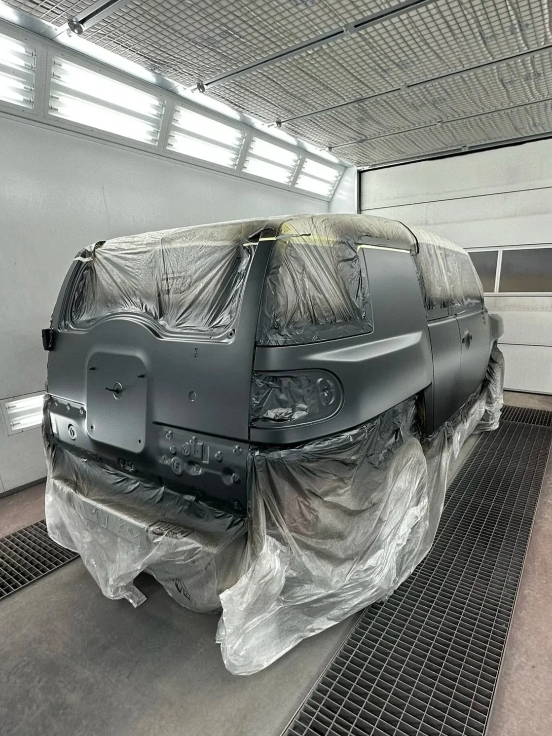 Youngtimer in spuitcabine tijdens restauratie bij Garage Van Beek Soesterberg