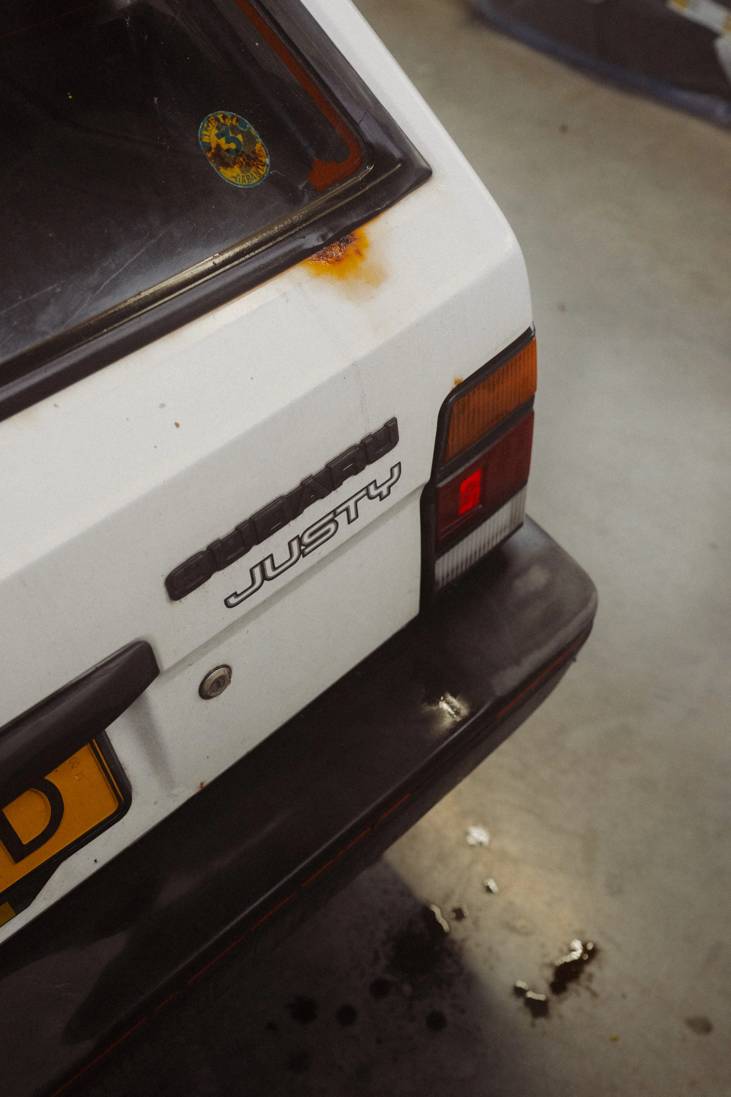 Achterkant Subaru Justy met roest rondom badge voor restauratie bij Garage van Beek Soesterberg