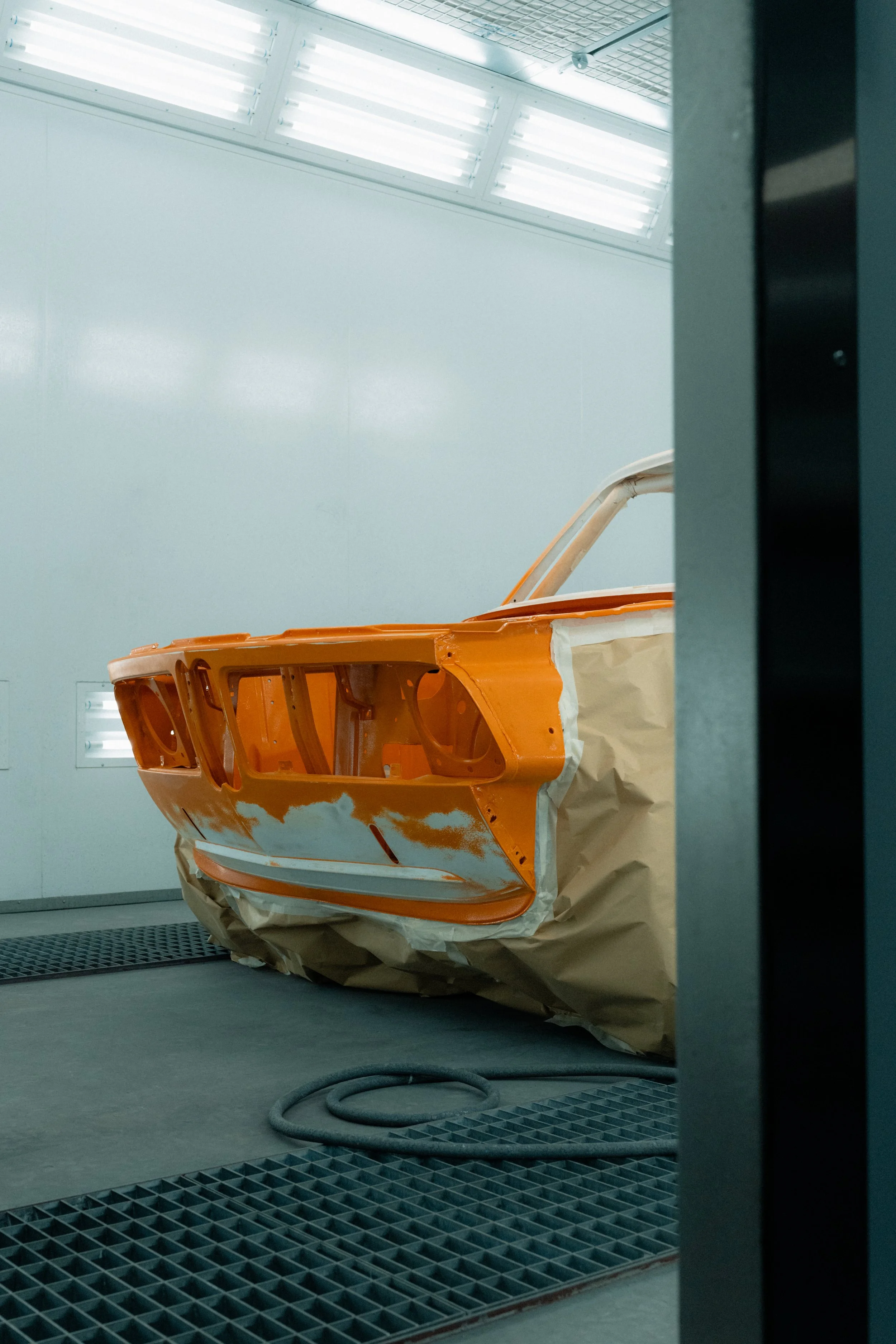 Voorkant van volledig gestripte BMW oldtimer carrosserie in oranje bij Garage van Beek Soesterberg