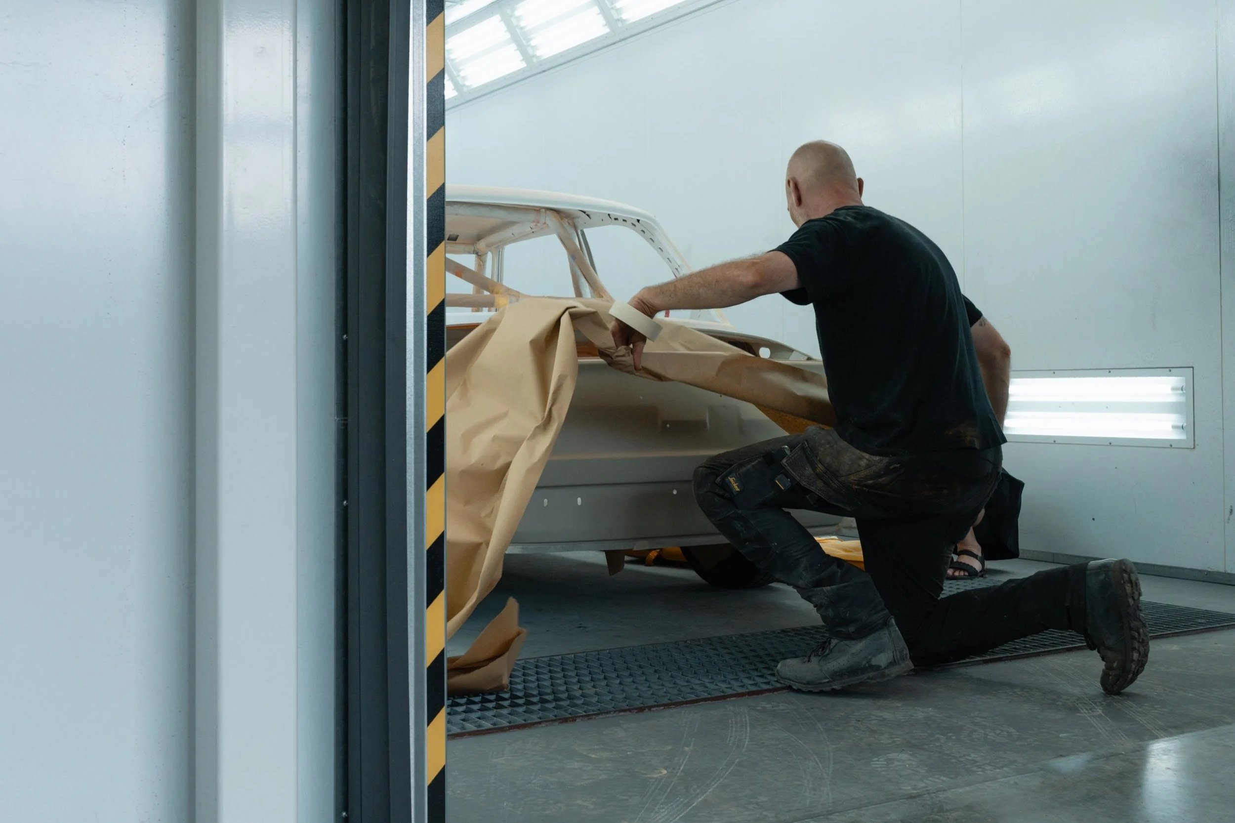 Spuiter van Garage van Beek plakt BMW oldtimer carrosserie af in de spuitcabine in Soesterberg