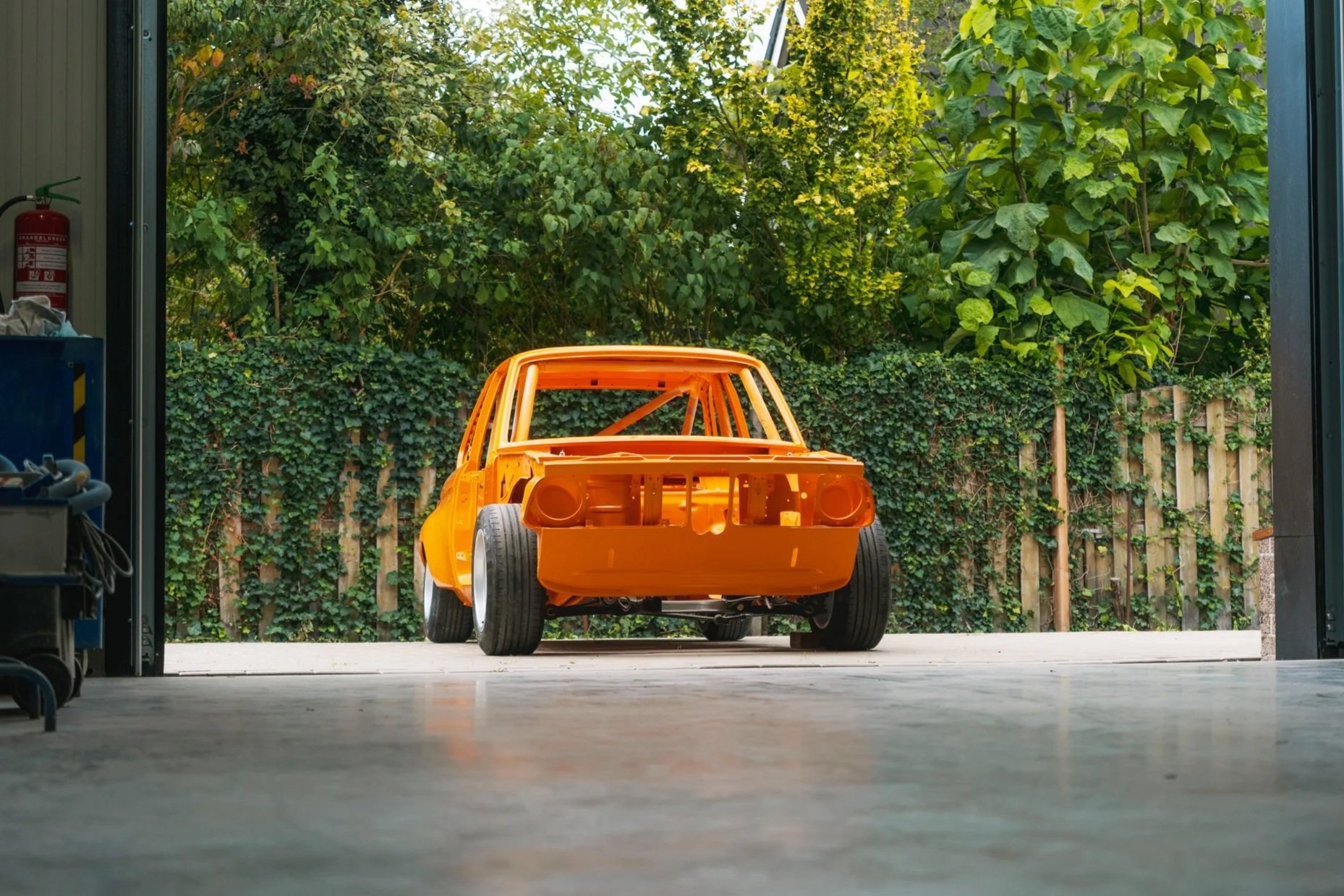 Volledig gestripte en oranje gespoten BMW oldtimer carrosserie buiten bij Garage van Beek Soesterberg, oldtimer restauratie