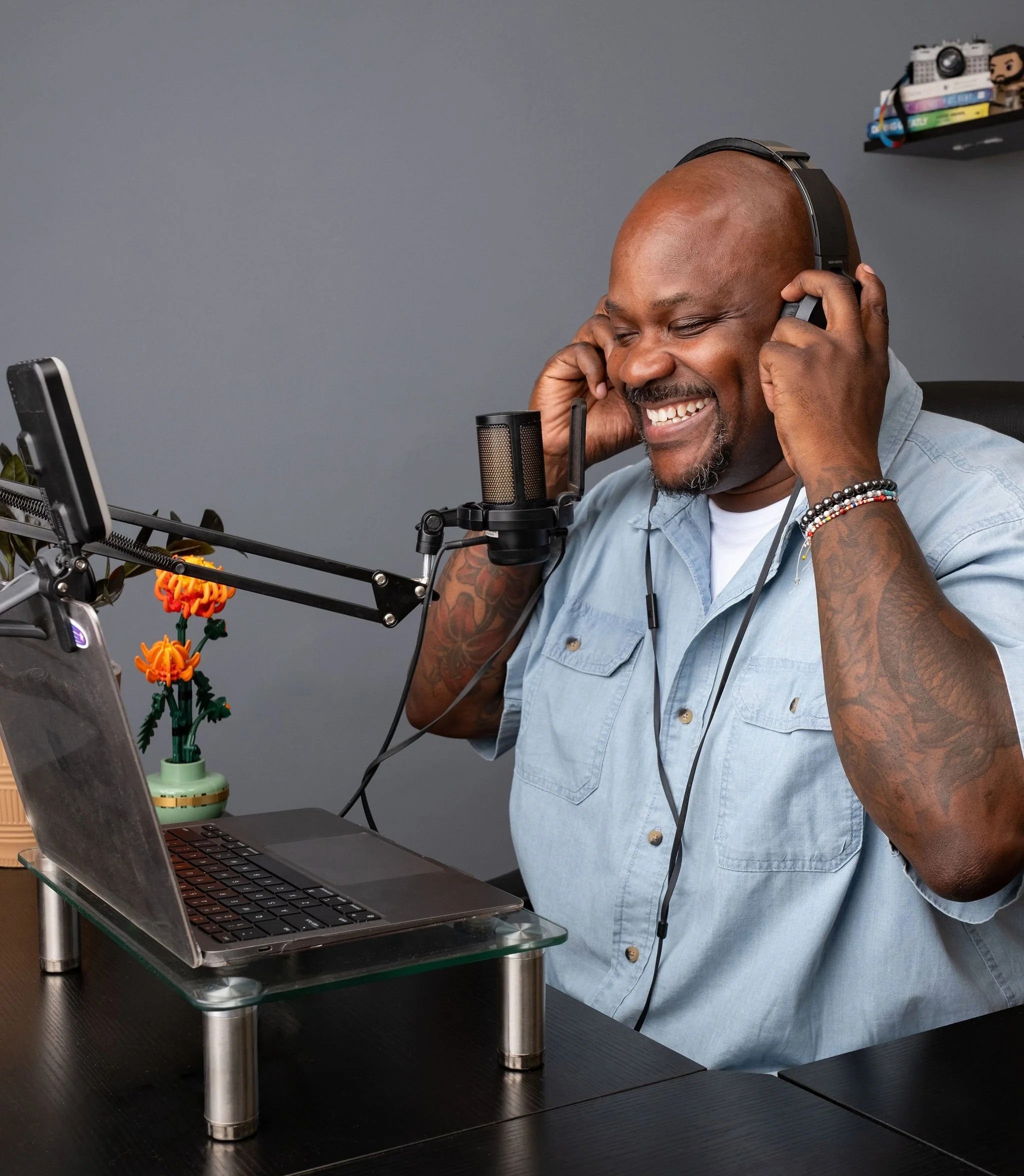 Will Wright smiling at his desk with his headphones on and a mic ready to record the I Am Self-ish Podcast