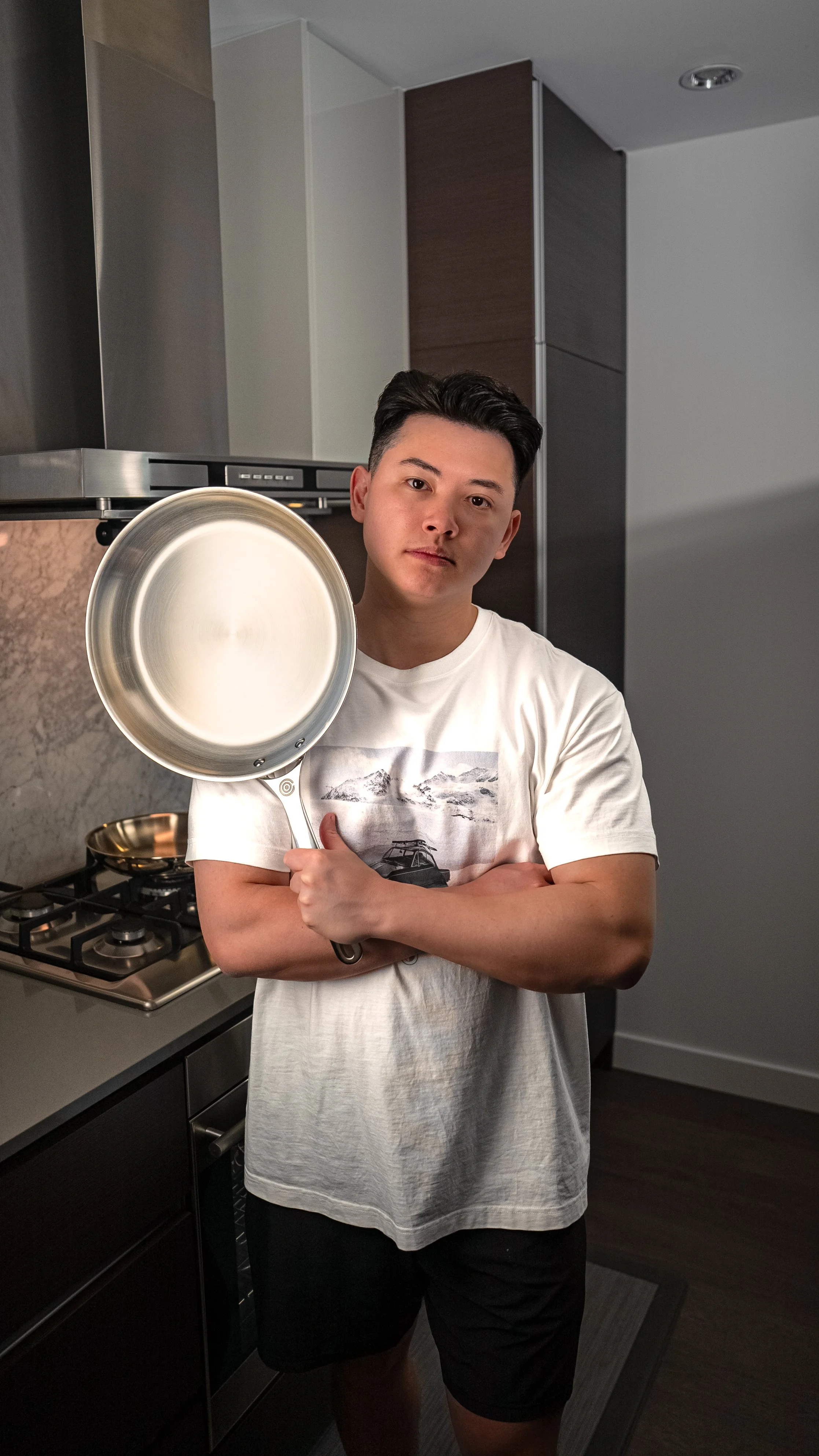 Will Wong holding a stainless steel pan in his kitchen