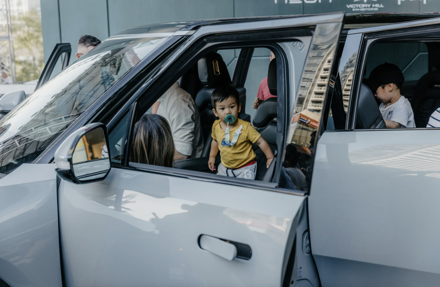 A toddler standing inside a Rivian with its doors open