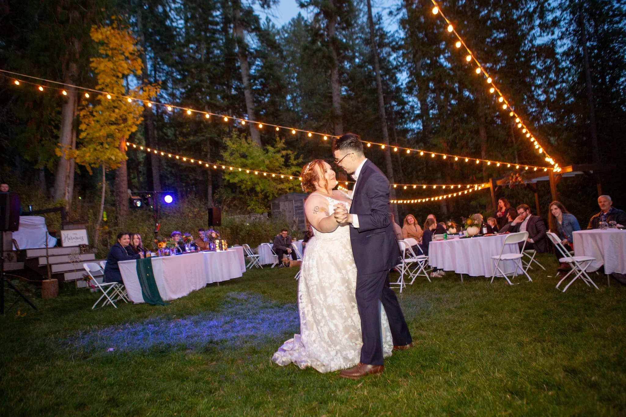 String lights and natural décor set the tone for an intimate outdoor wedding reception at our riverfront venue near Coeur d’Alene, Idaho.