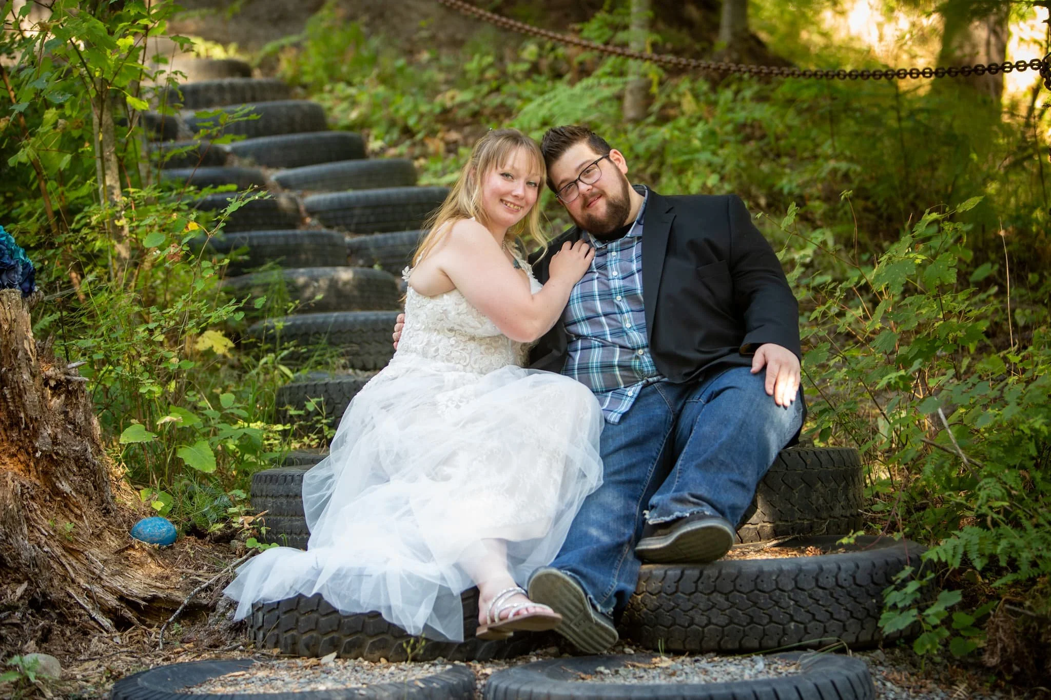Bride and groom sharing a moment on the re-purposed tire stairs at Cedar River wedding venue not far from Spokane 