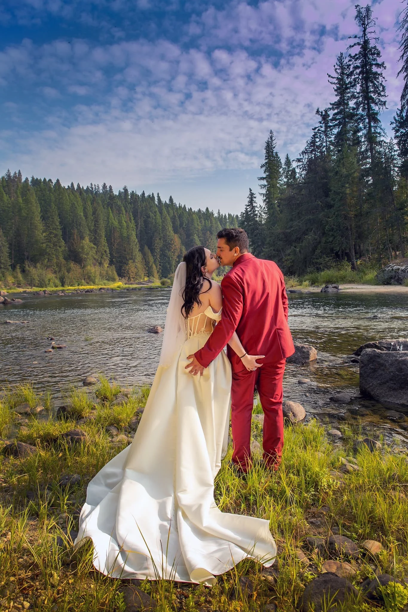 Bride and Groom kissing on rivers edge at golden hour