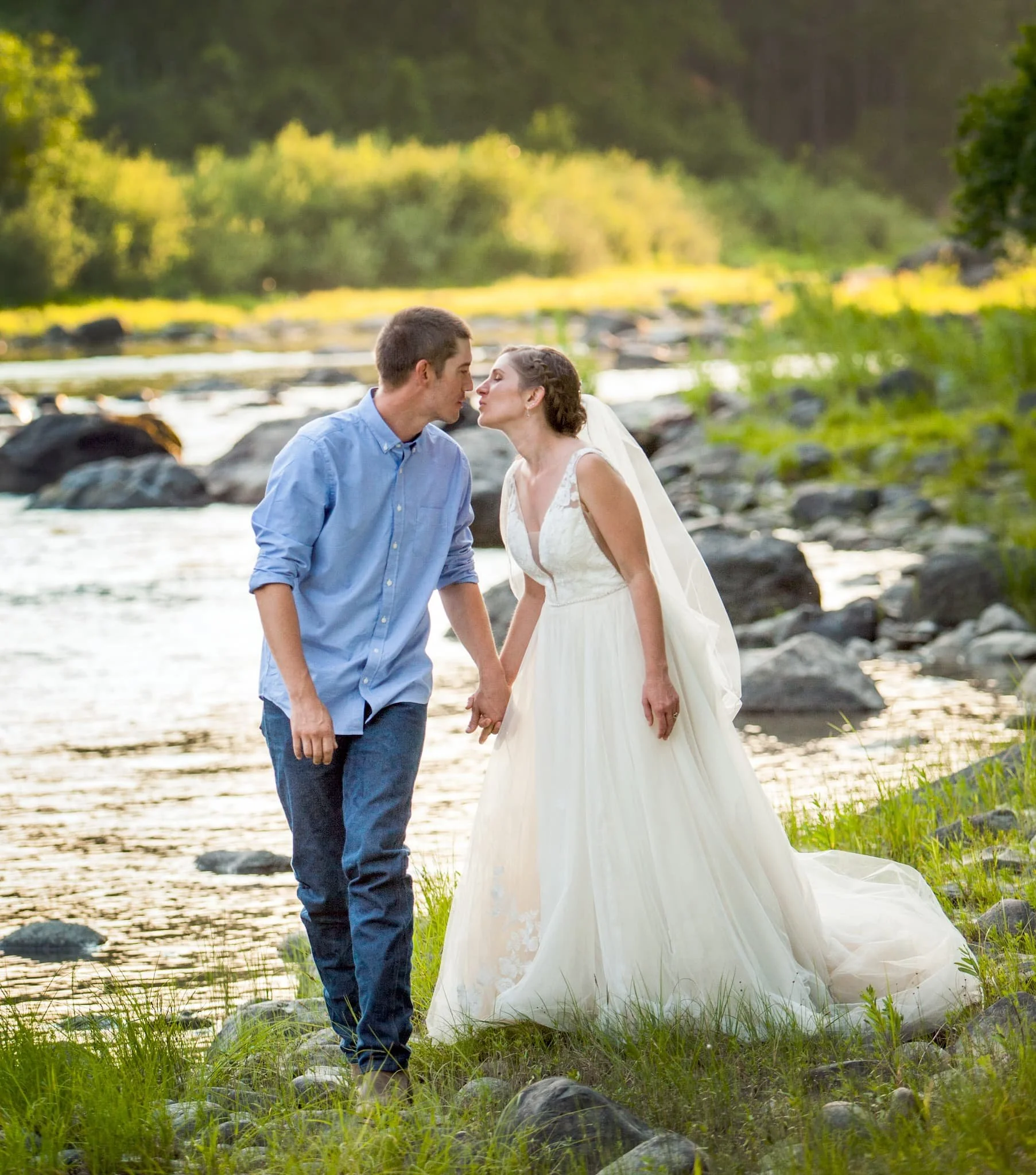 Couple strolling along the river of this country backwoods wedding venue not far from town in North Idaho