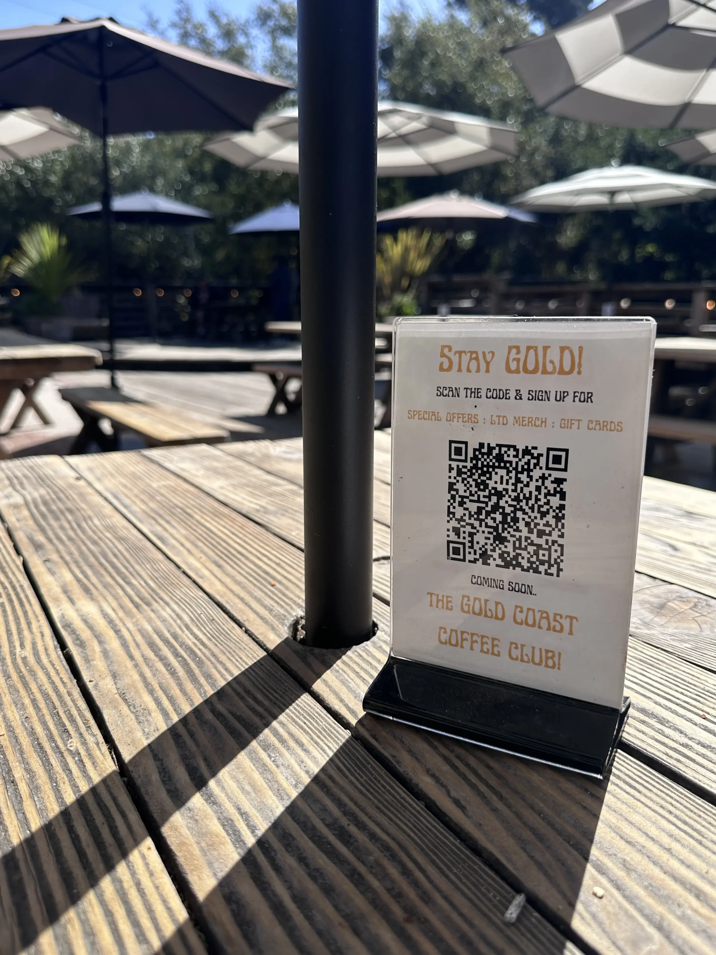 Stay Gold table sign with QR code on the outdoor patio