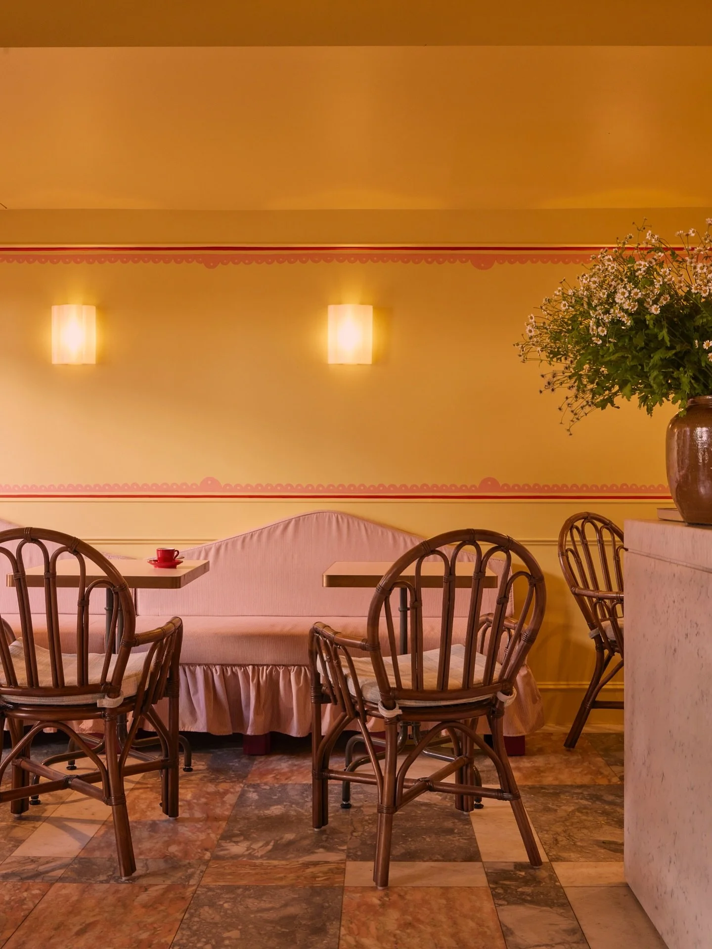 Caf&eacute; Cressida carries the charm of yesterday with the freshness of today. Random marble floors and rattan chairs ground the space in memory, while hand-painted borders lift it with playful rhythm. Whimsy drifts through the details, nostalgia l