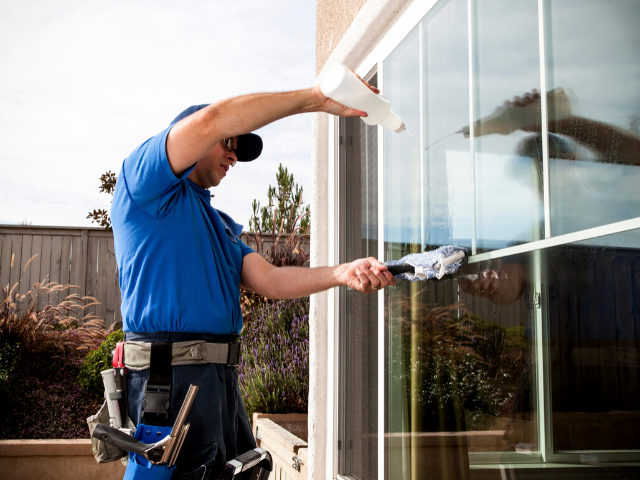 window cleaner cleaning windows at a home