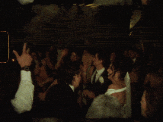 People dancing and socializing at a nighttime party or event, some in formal attire.
