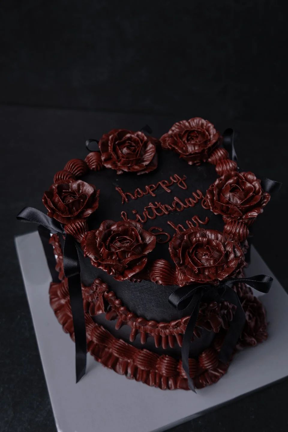 custom romantic birthday cake with a black base and deep gothic red vintage piping with buttercream roses on top in Eugene OR