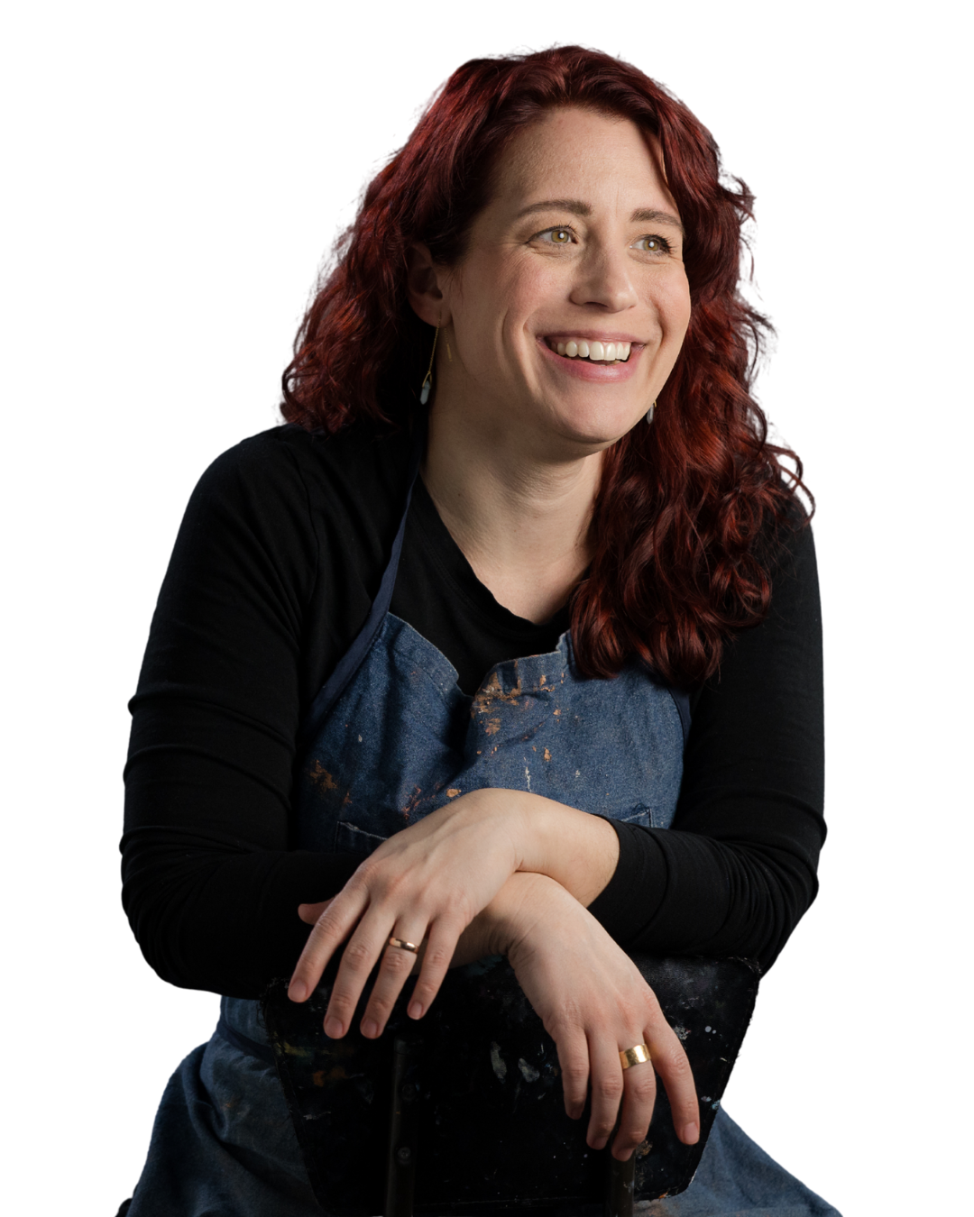 Rebecca sitting in a chair backwards smiling with her arms resting on the back of the chair