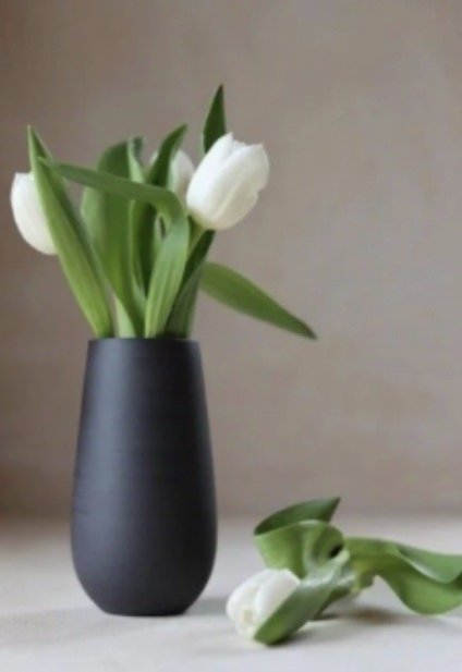 White flowers in a small black vase