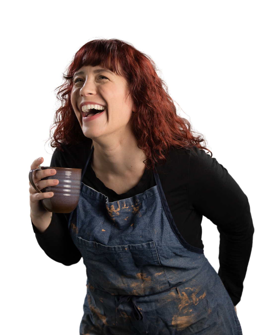 Rebecca laughing in an apron while holding a mug