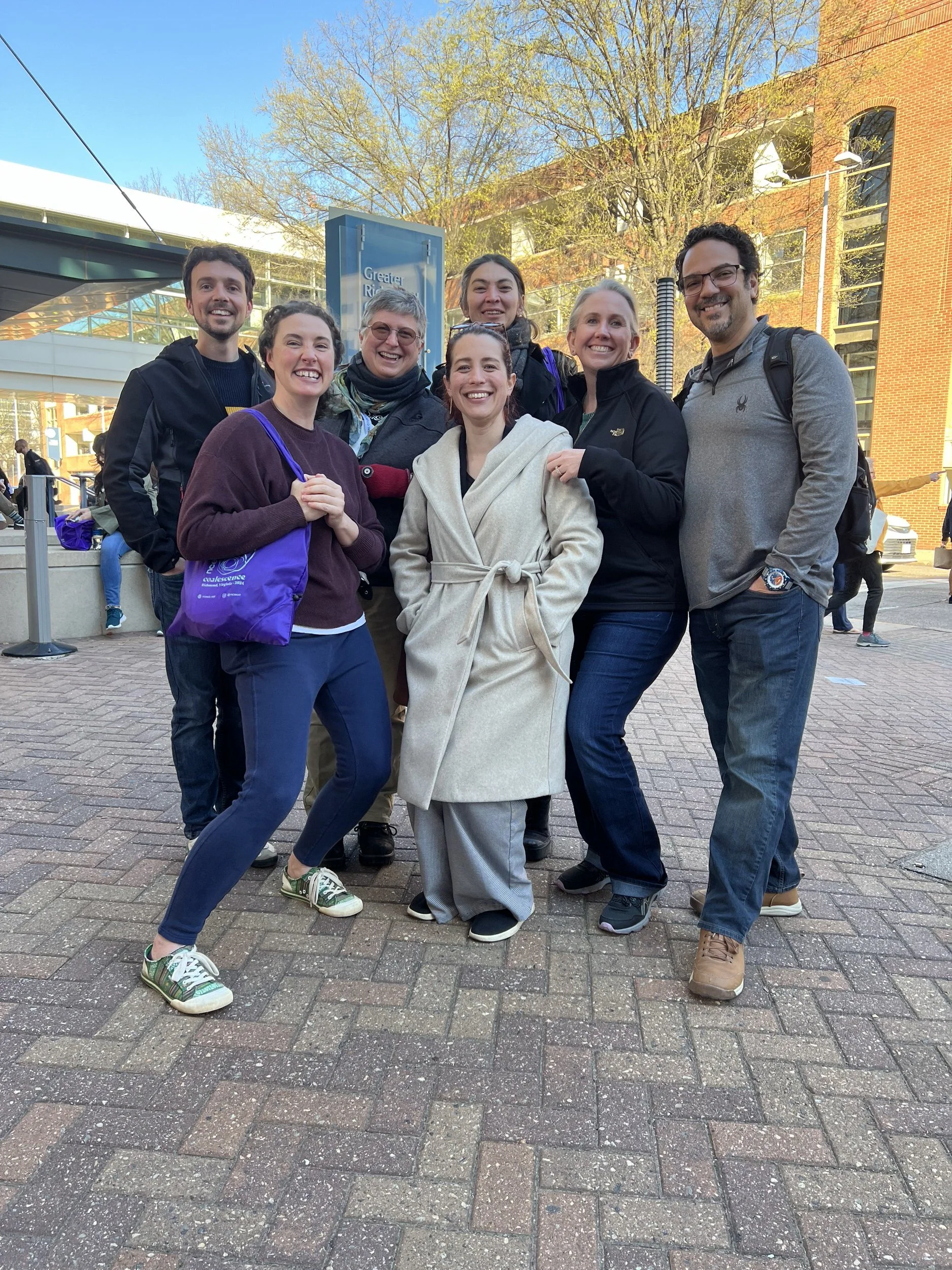 A group of people standing outside smiling together