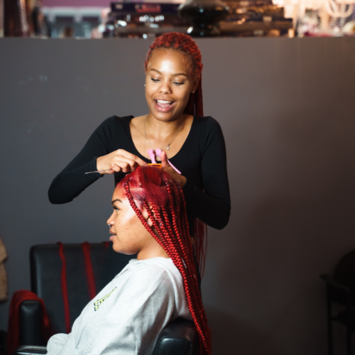 Hairstylist braiding a woman's hair