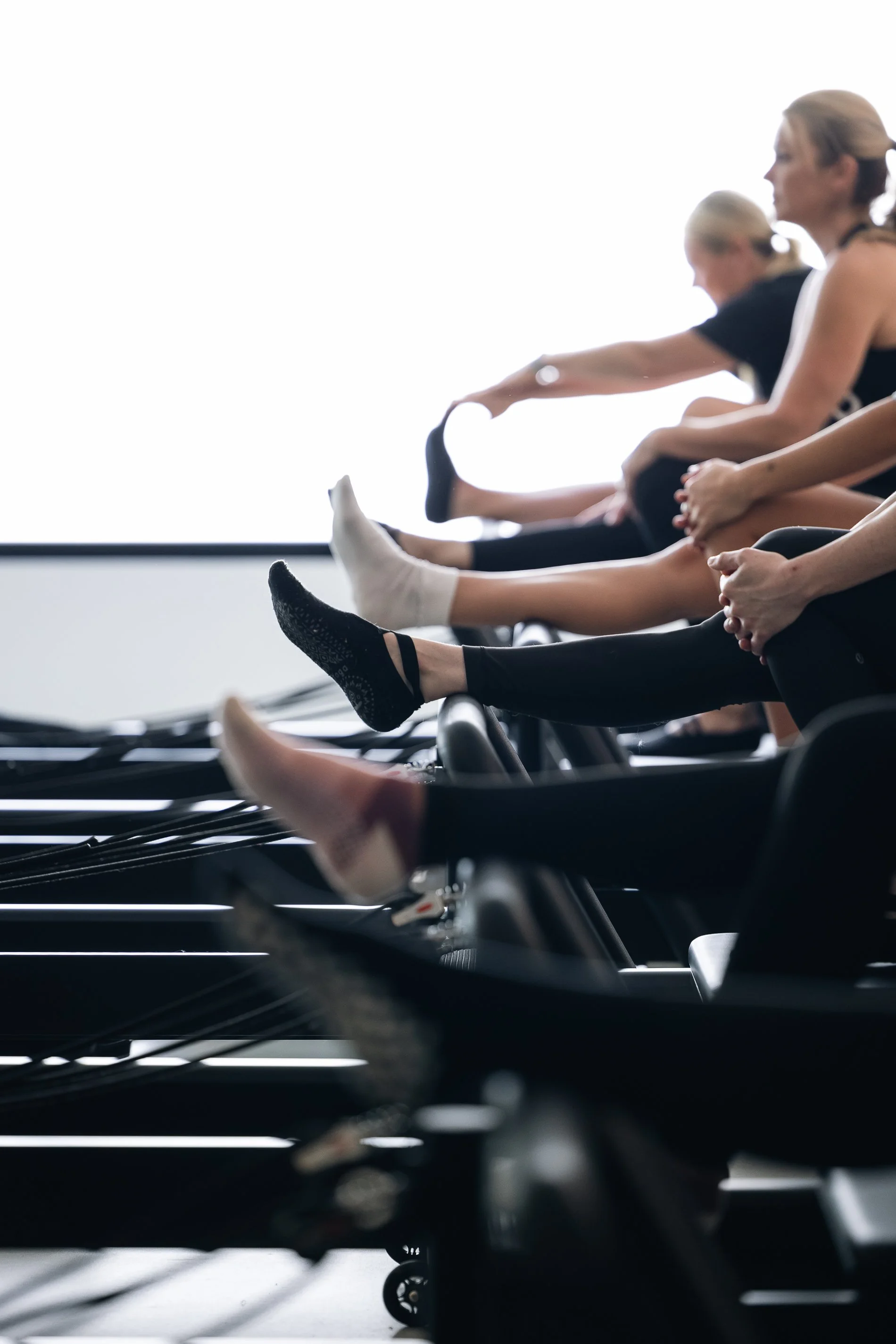 People using exercise bikes in a gym with bright lighting.