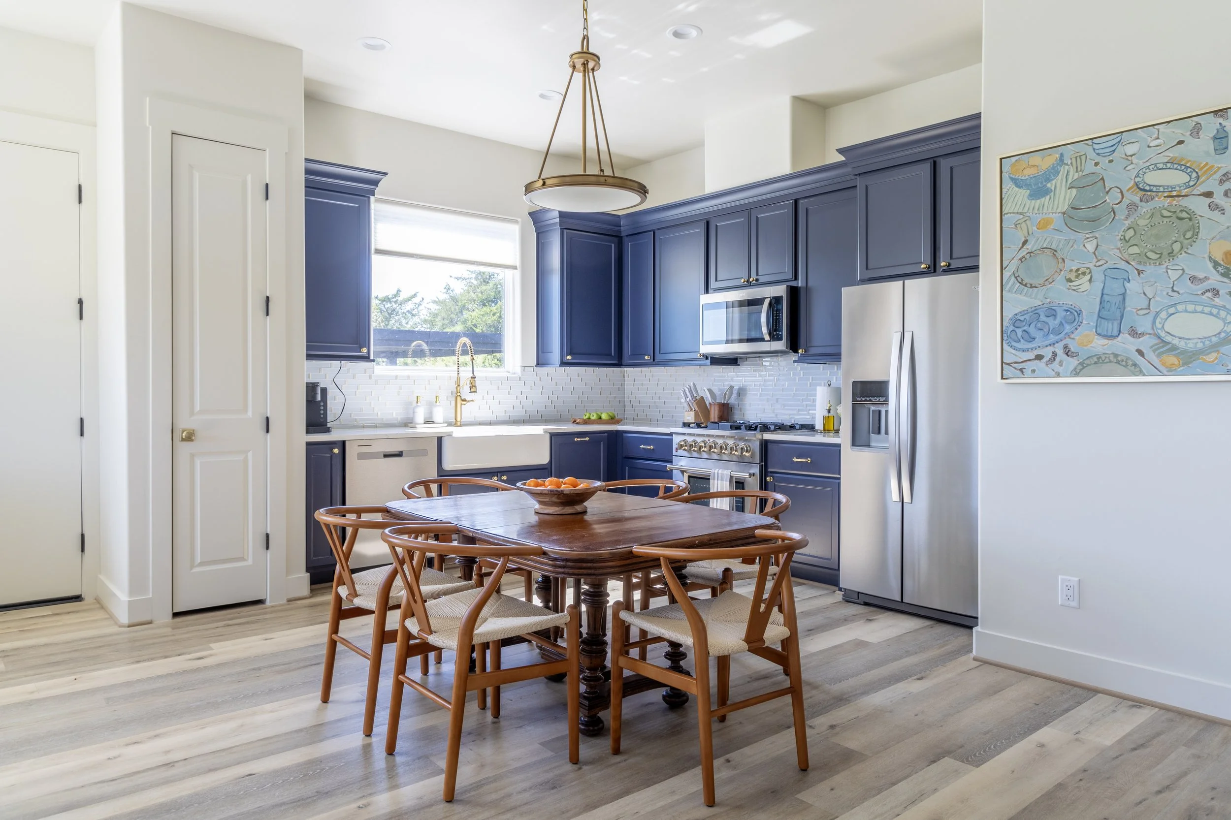 Blue kitchen cabinets fill the kitchen and dining space of the Water Retreat at Element Ranch in Round Top, Texas