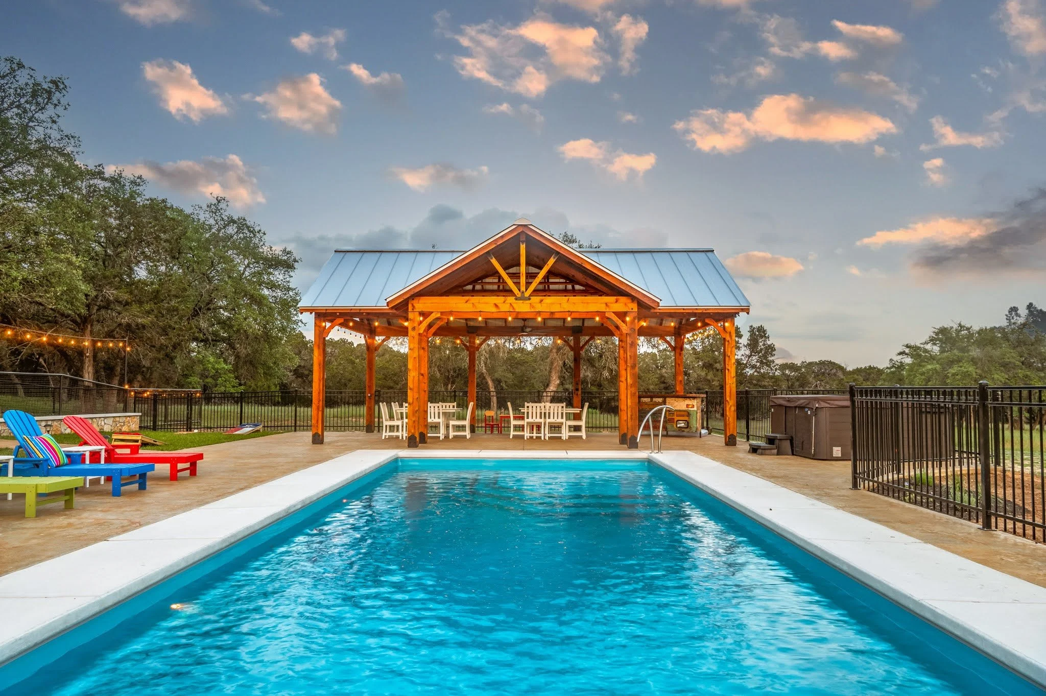 Green chef's kitchen and stone fireplace inside The Gathering house in Wimberley, TX