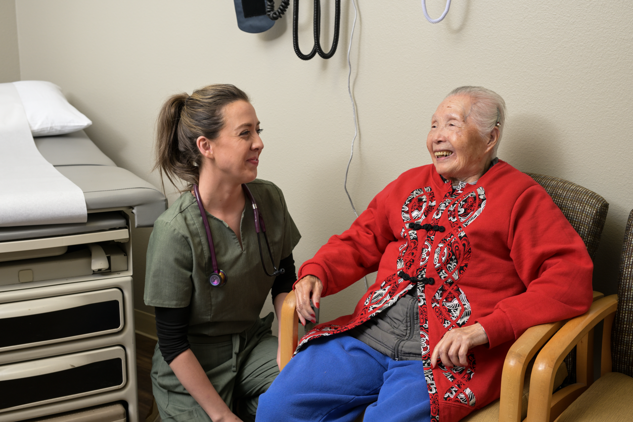 Hayden smiles with a patient in an exam room at Upper County Primary Care