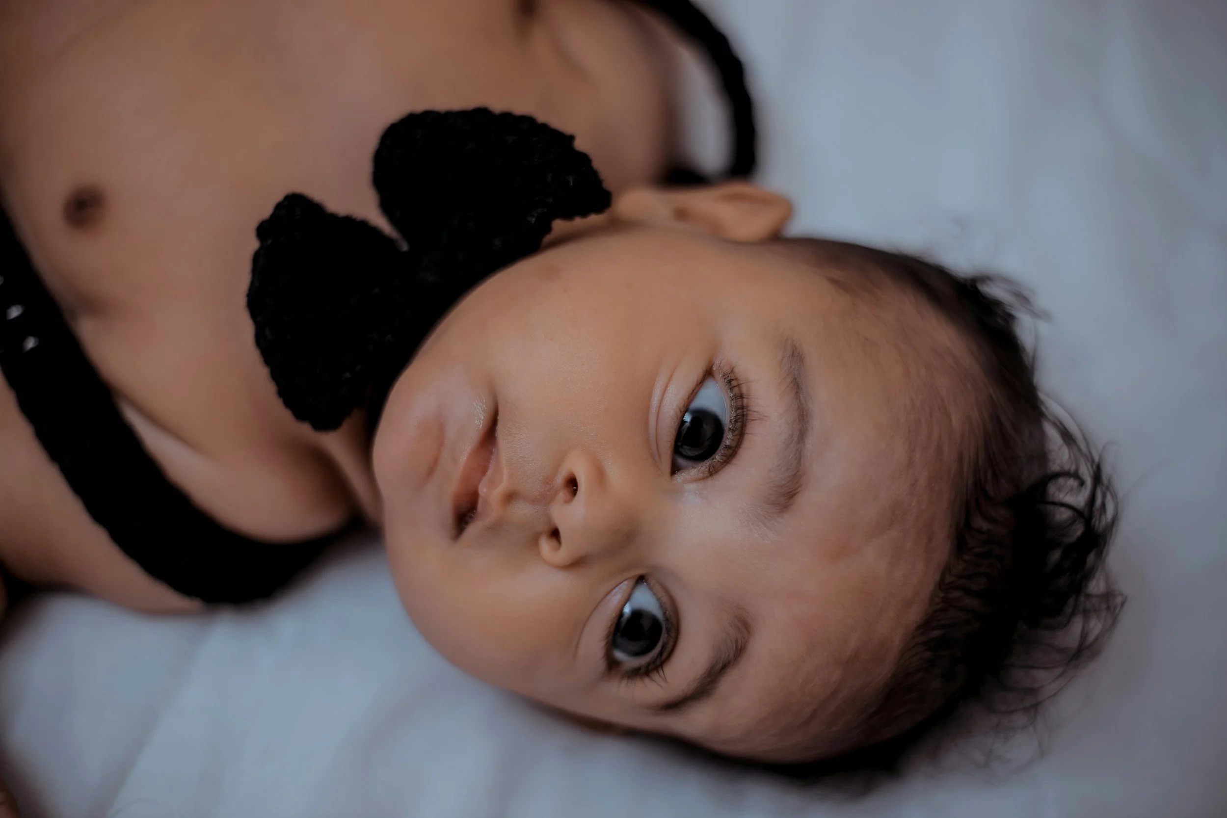 infant lying on bed, looking up
