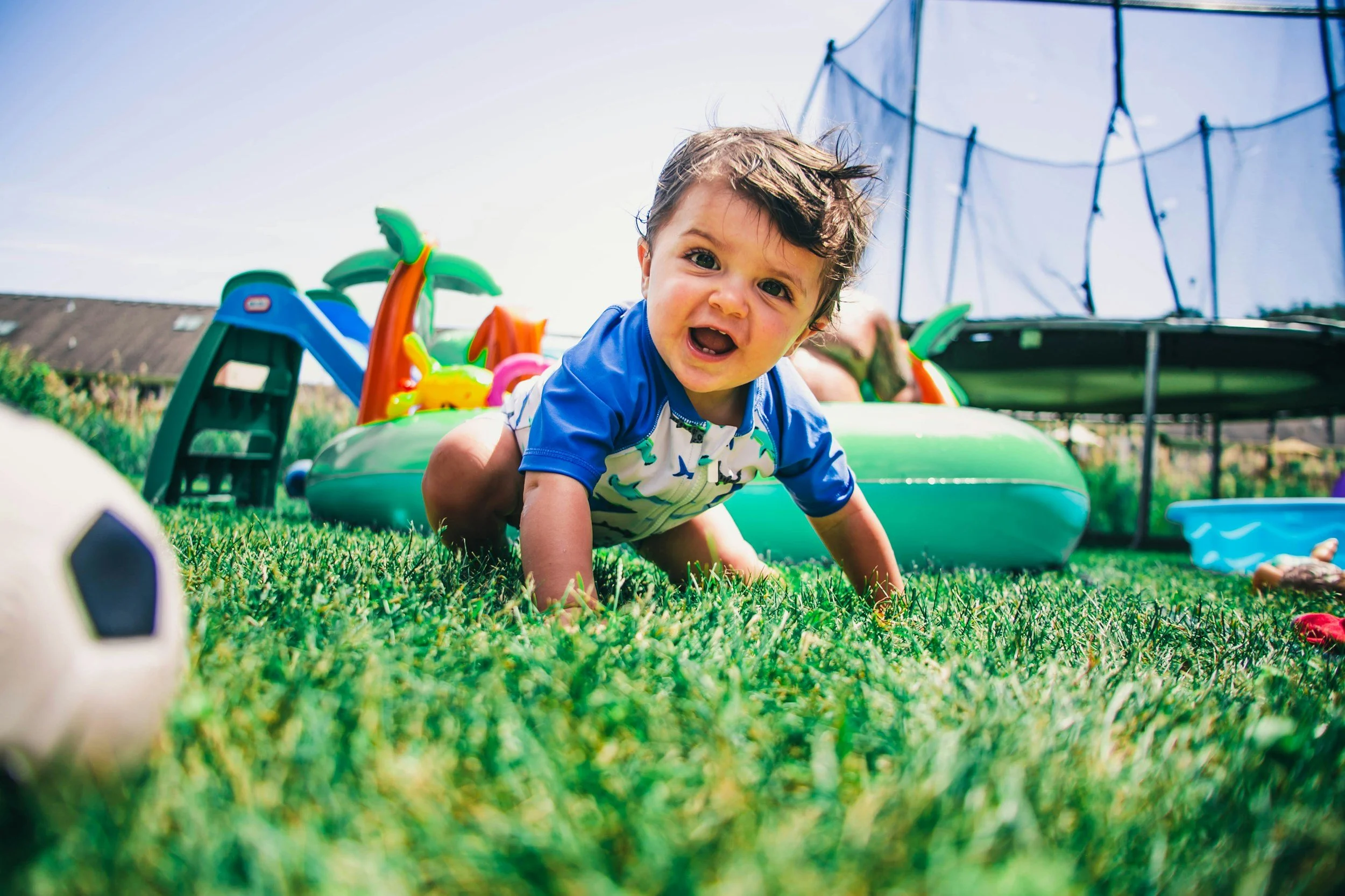 baby playing outdoors with soccer ball