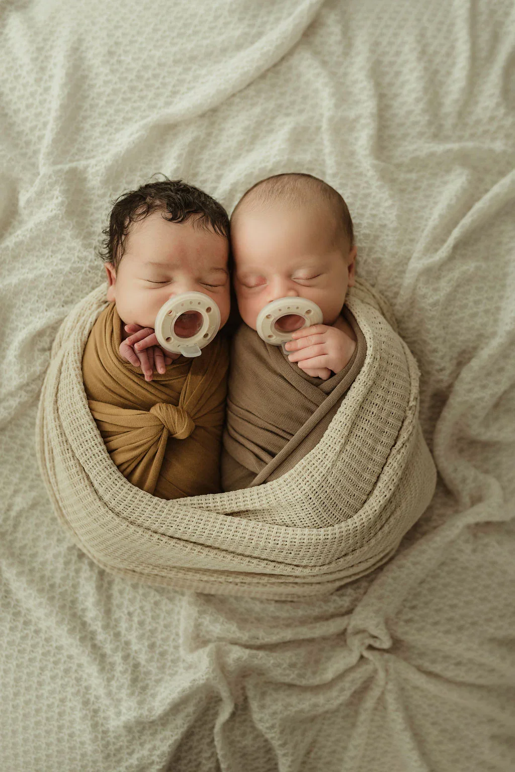 twins swaddled with ninni pacifiers