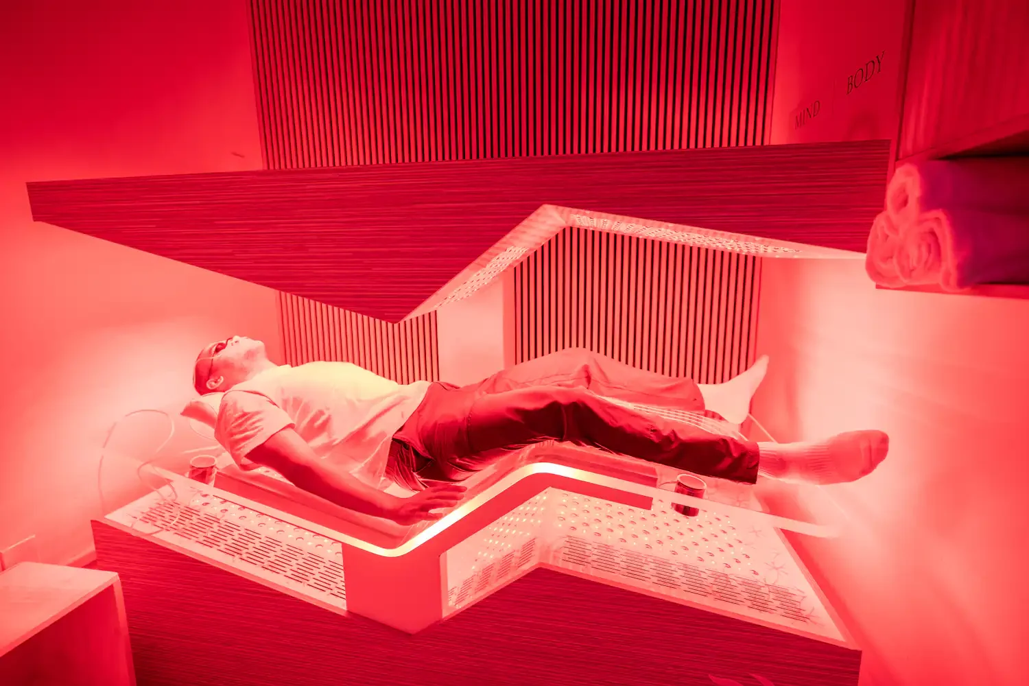 Client lying in the Ammortal Chamber under red light at Biohack Cryo & Wellness in Woodland Hills