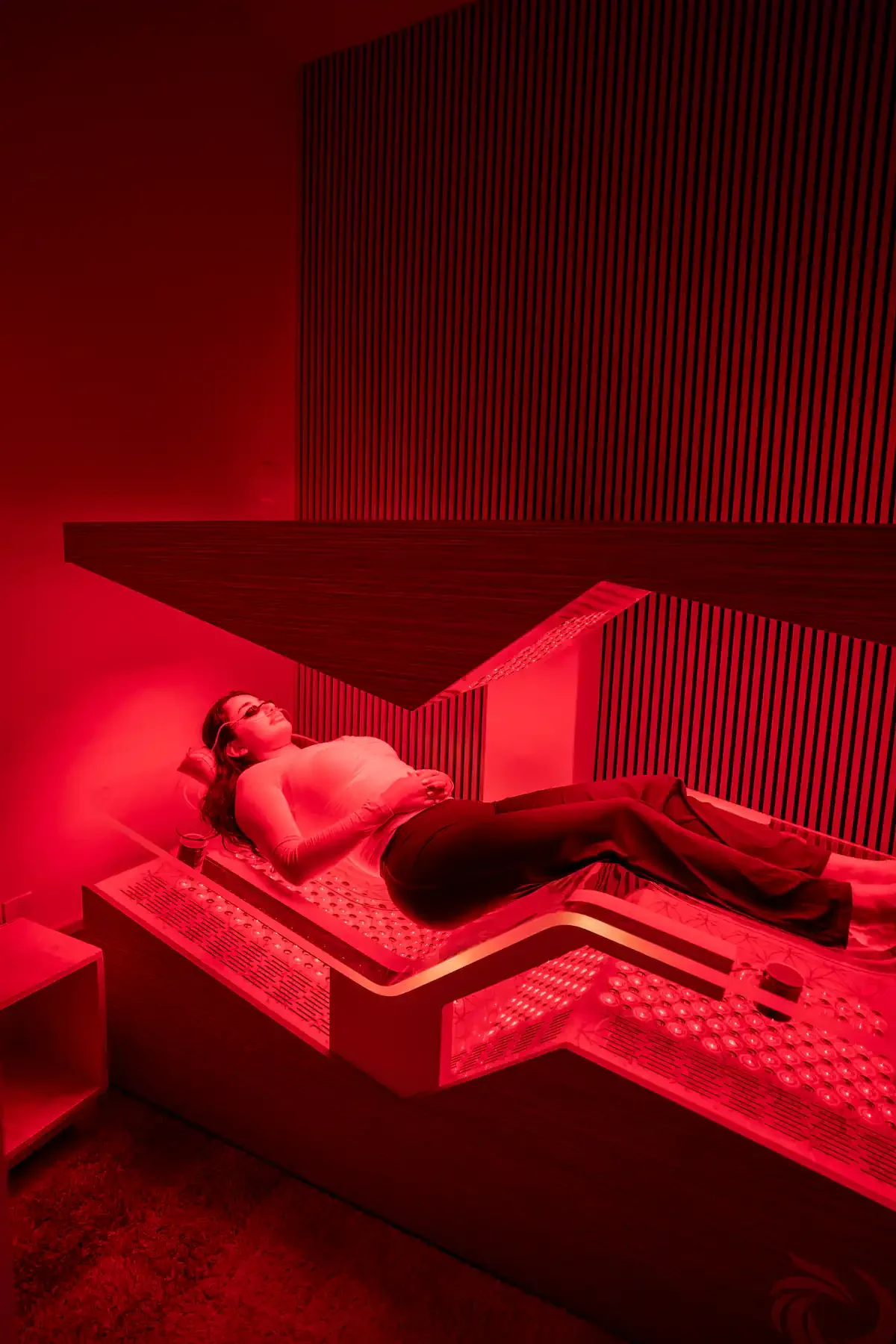 Client relaxing in the Ammortal Chamber during a red light and PEMF session