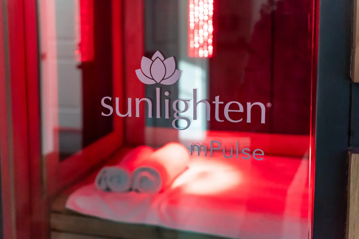 Sunlighten mPulse infrared sauna with red light glow at Biohack Cryo & Wellness