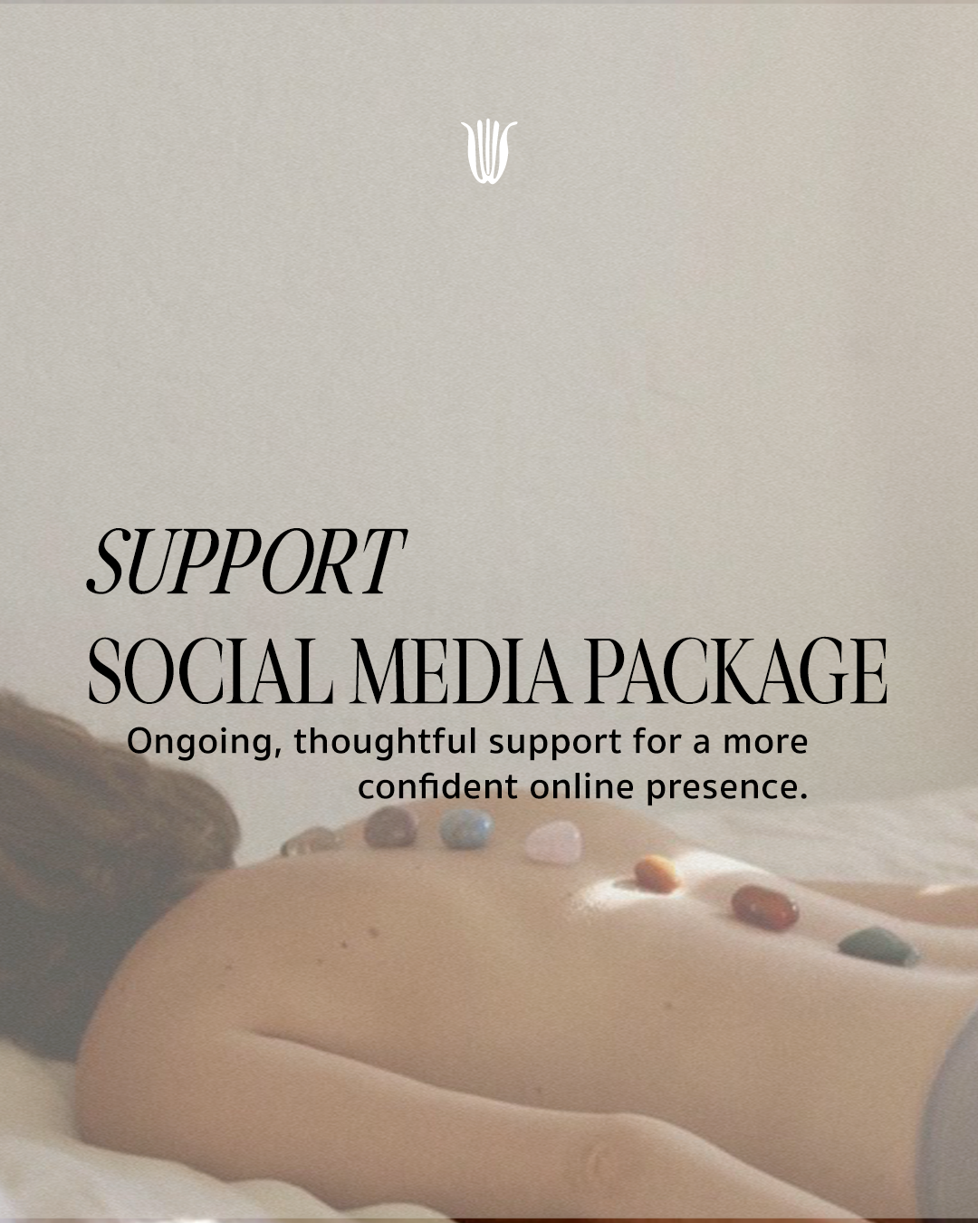 A person lying on their stomach, with their back visible, decorated with small colorful stones or beads.