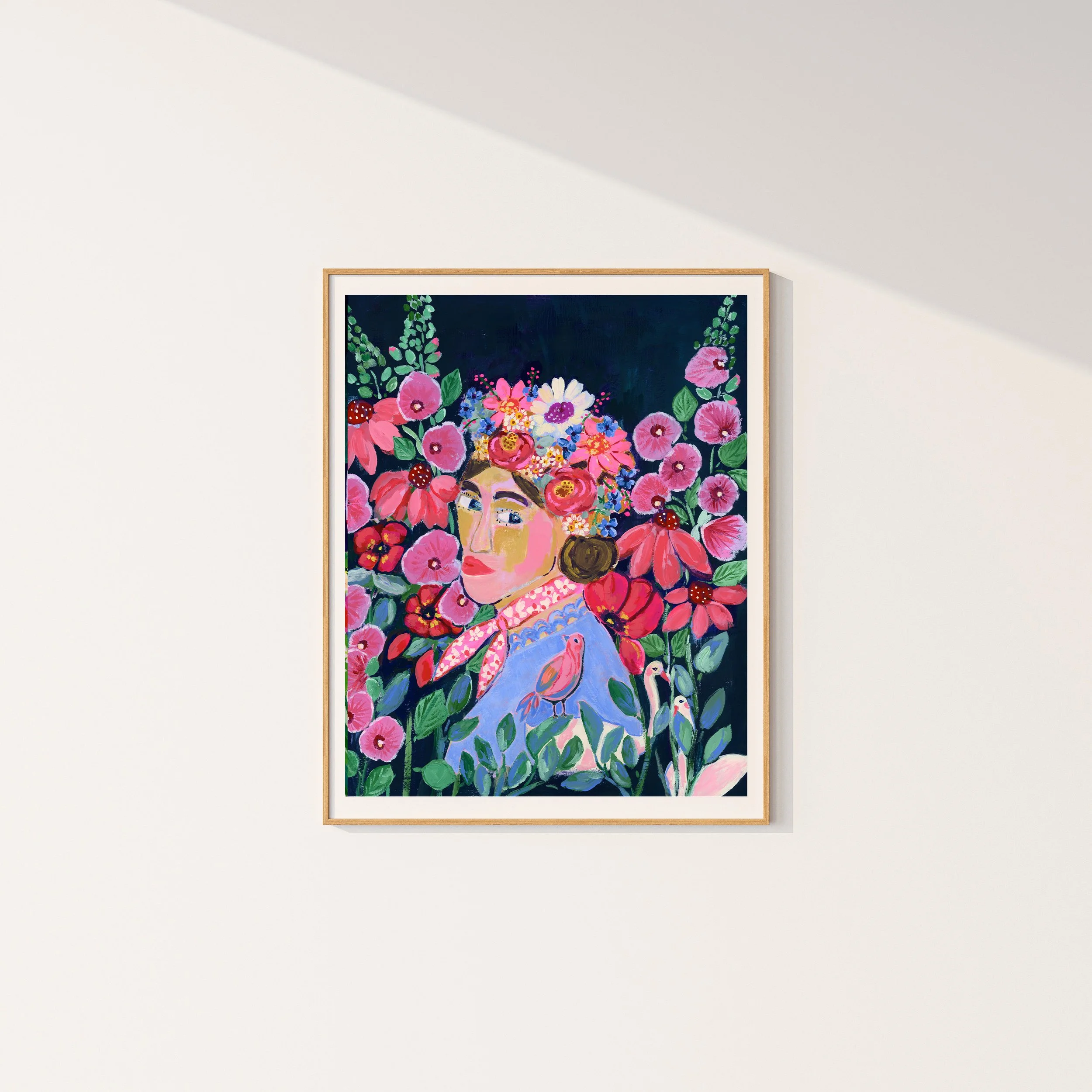 My Frida — a fine art print in simple frame, with a lovely women looking at you. She is wearing a flower crown and surrounded but lush flowers and darling animals like 2 swans and a birds.
