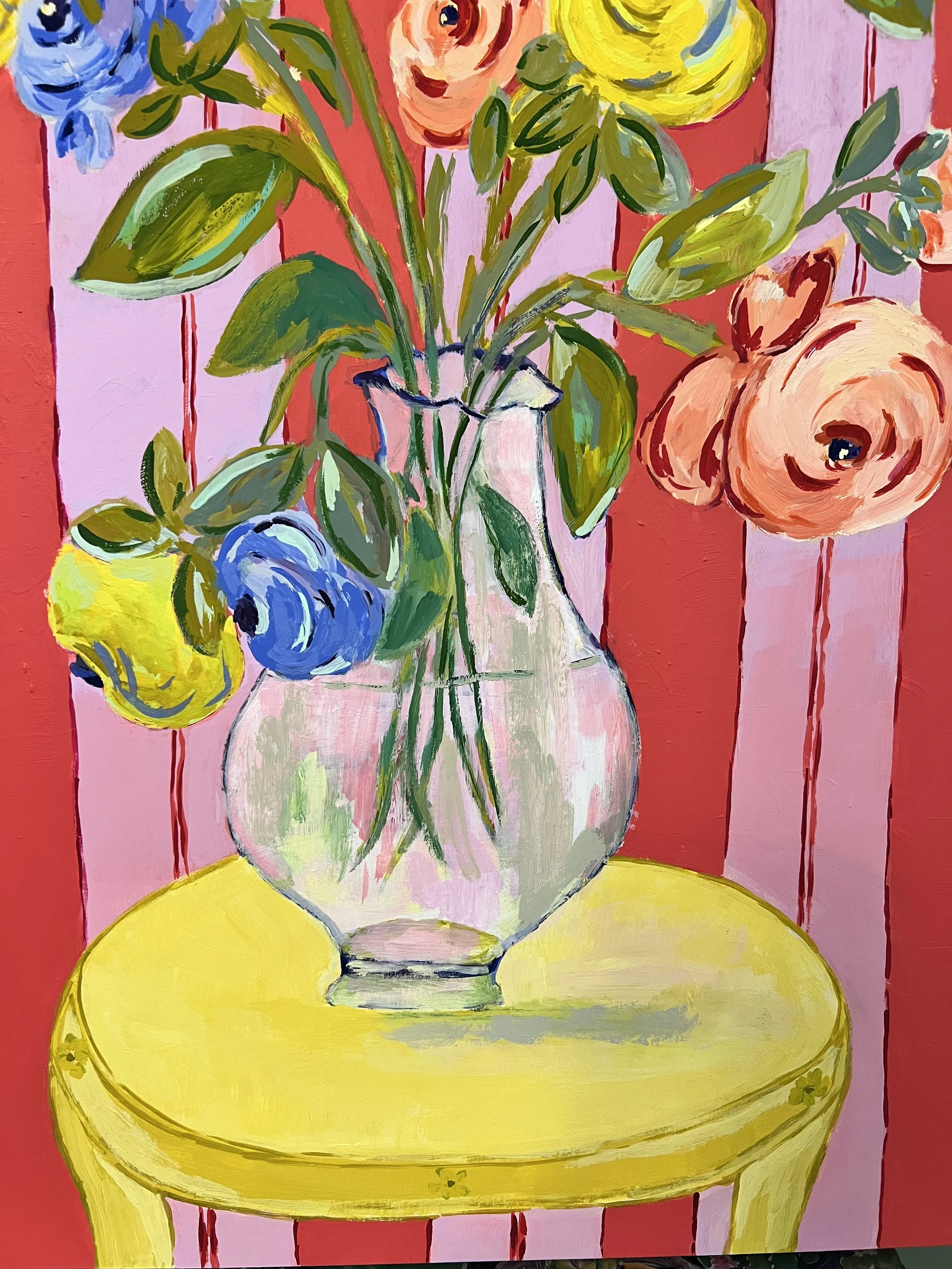 Grand Arrangement of a large bouquet of ranunculus in a transparent vase on bright yellow table. Red and lavender background.