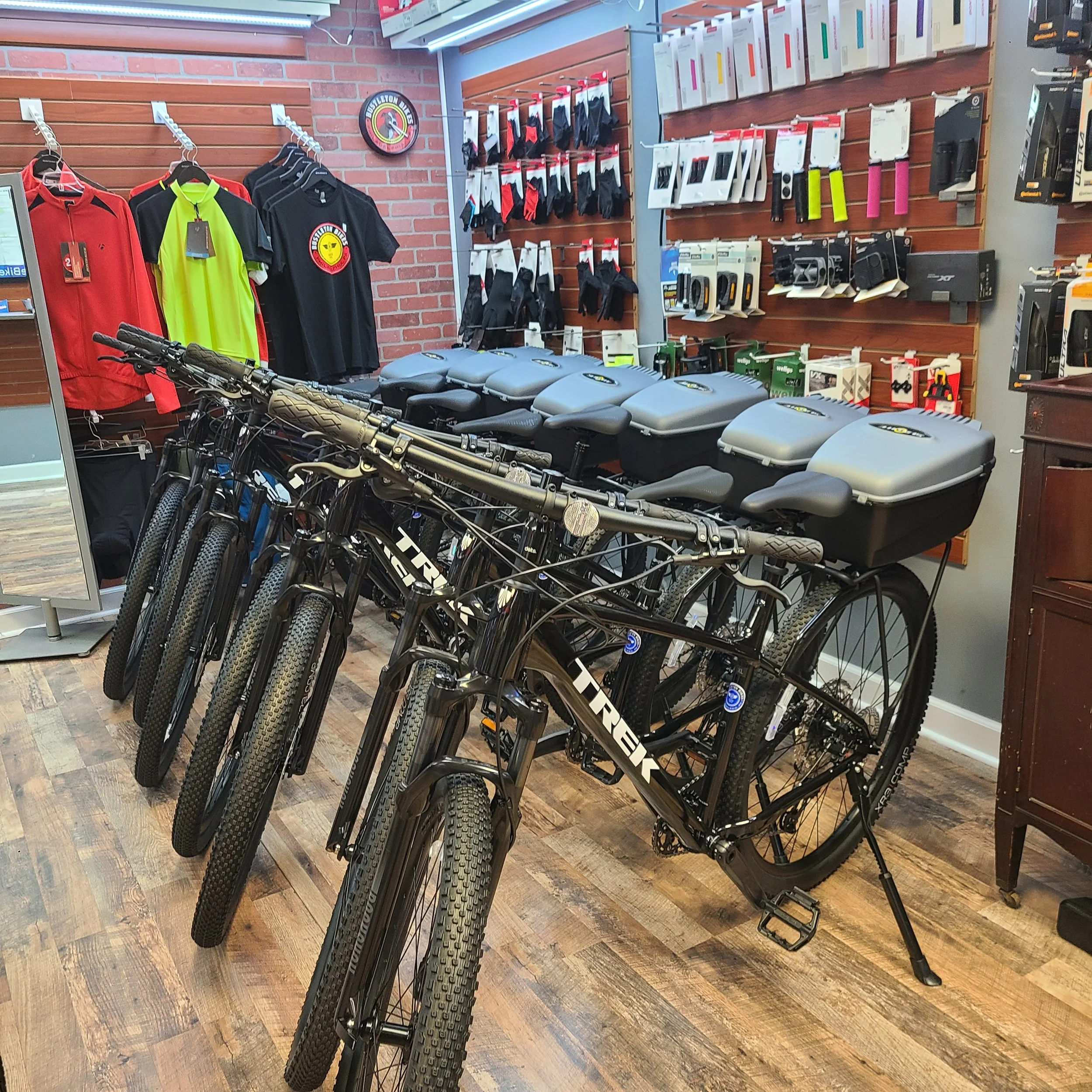 A large fleet of matching black police duty bicycles lined up neatly across the showroom floor inside the shop after assembly