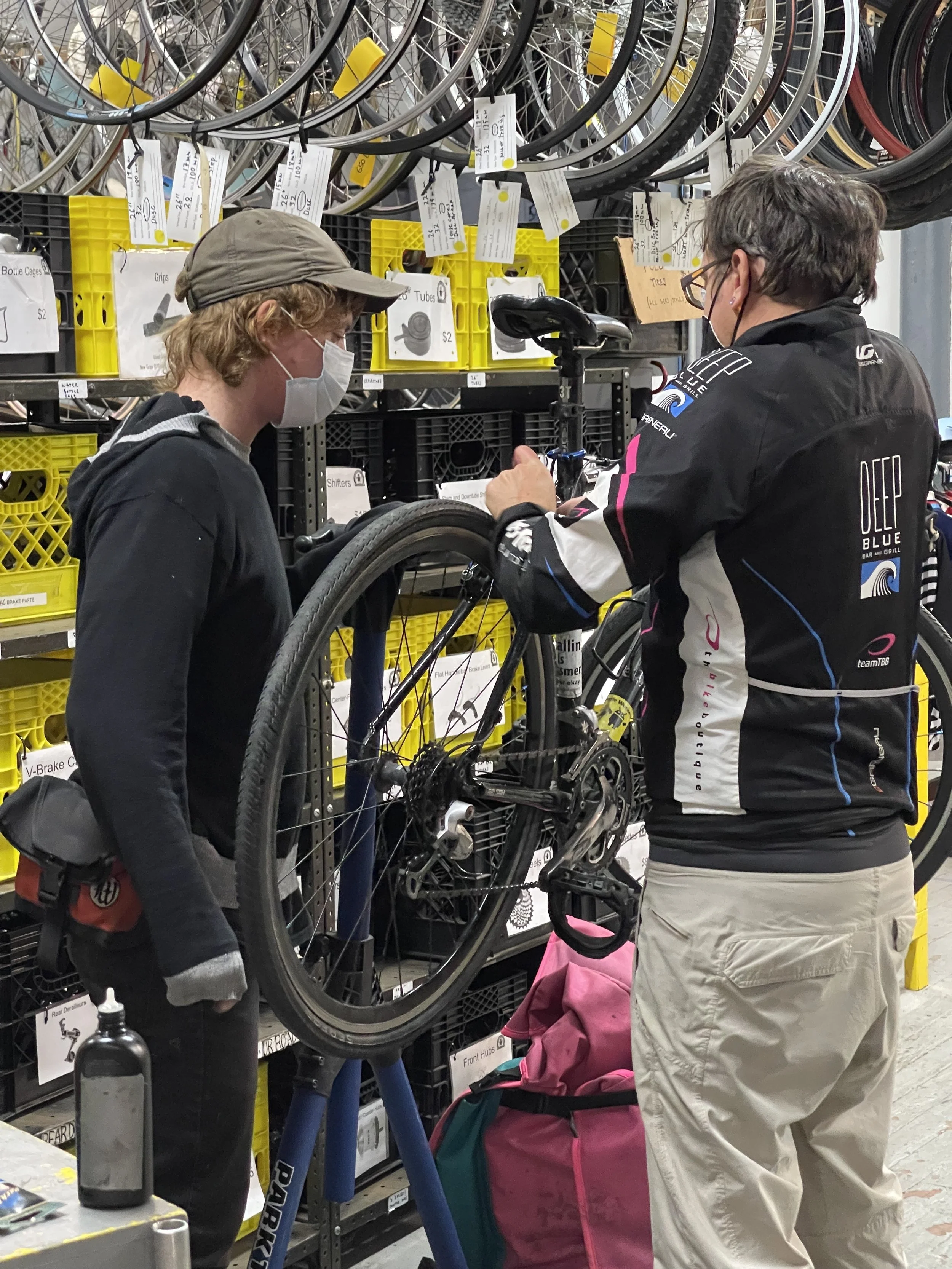 Two people working together on a bicycle repair stand during the Bike Church community program.