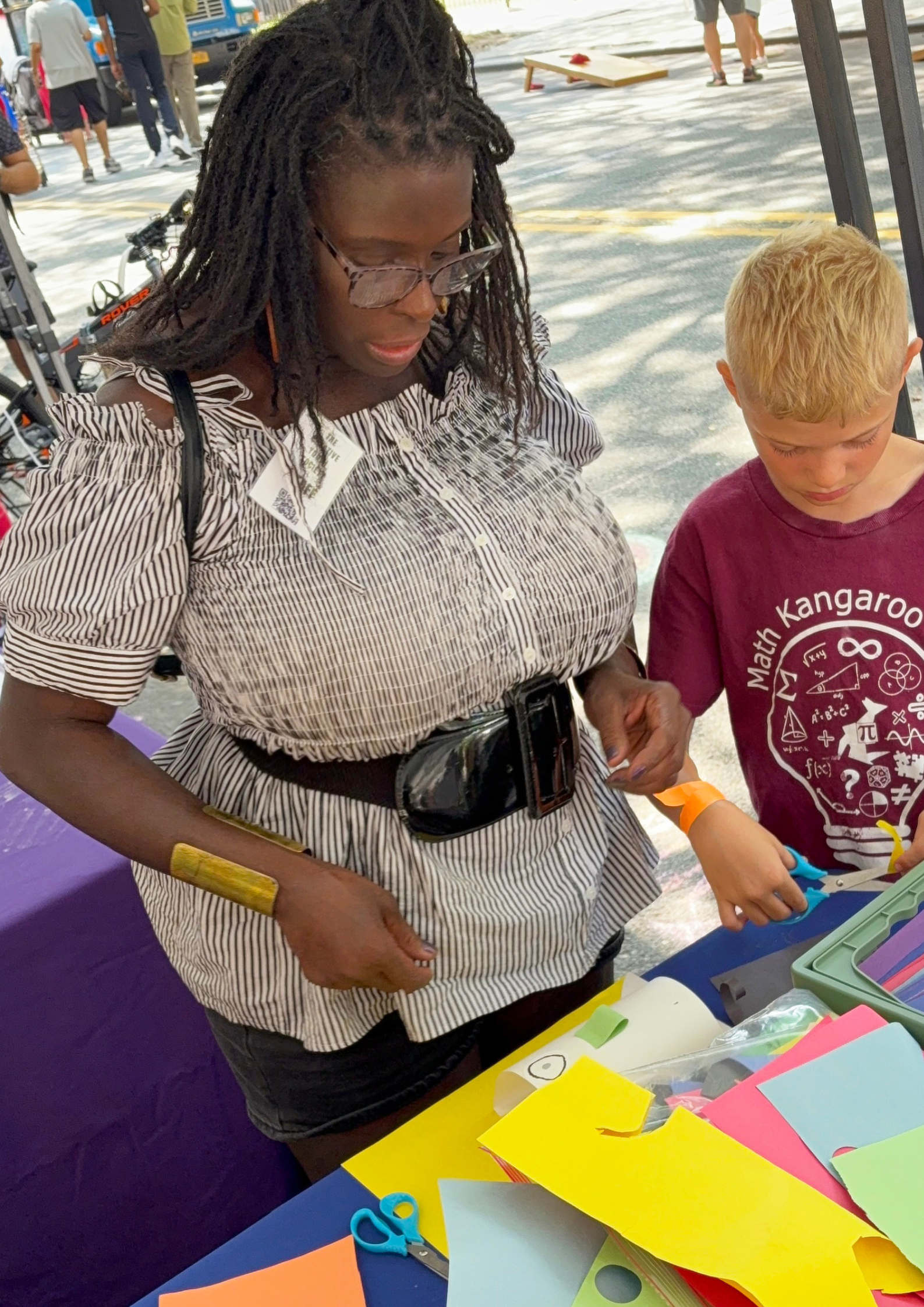 CYS Founder, Sharon Miller assisting a young participant at the CYS art station during NYC DOT Summer Streets.