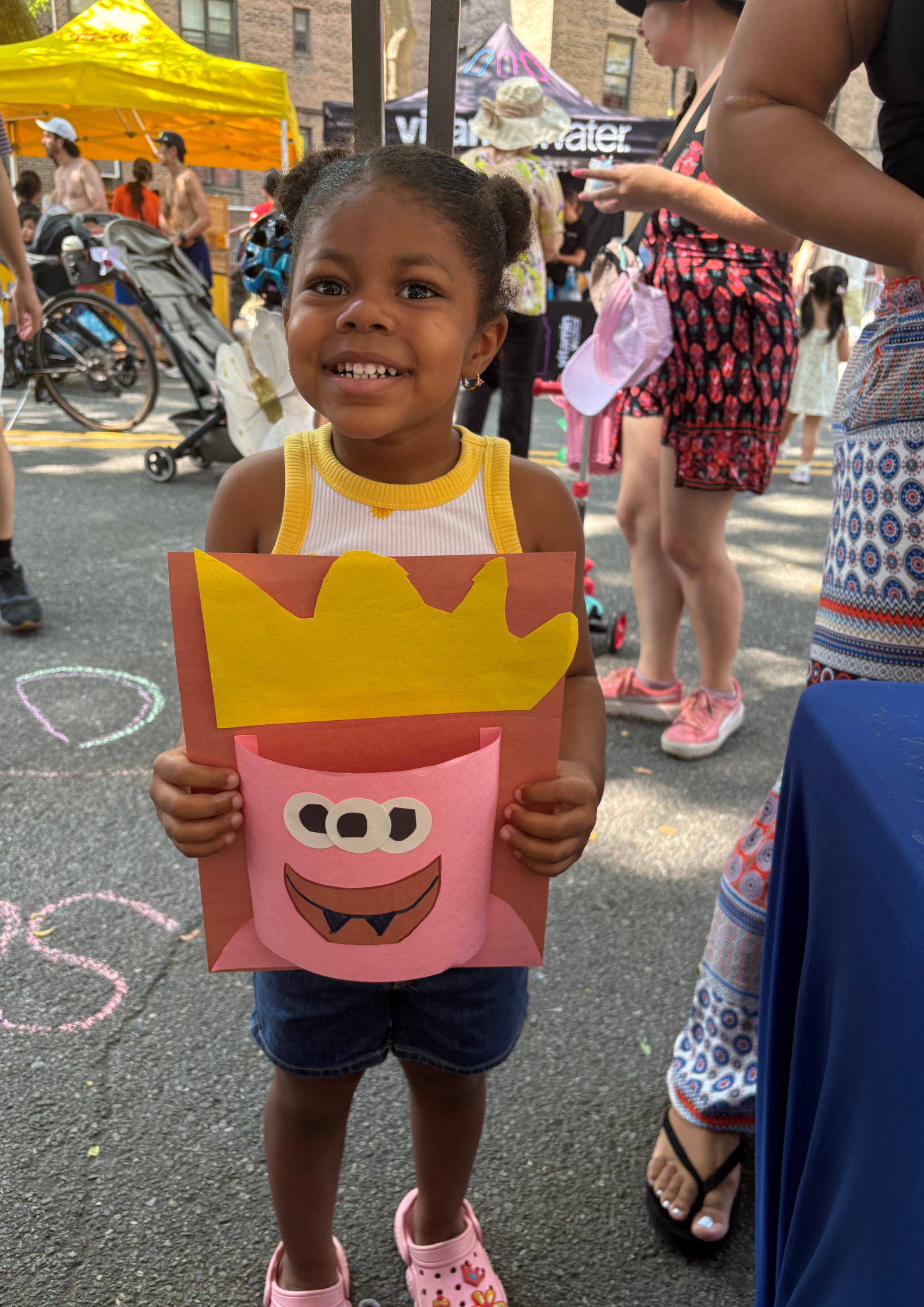 A young participant proudly showing off their artwork at our CYS x NYC DOT Summer Streets art station.