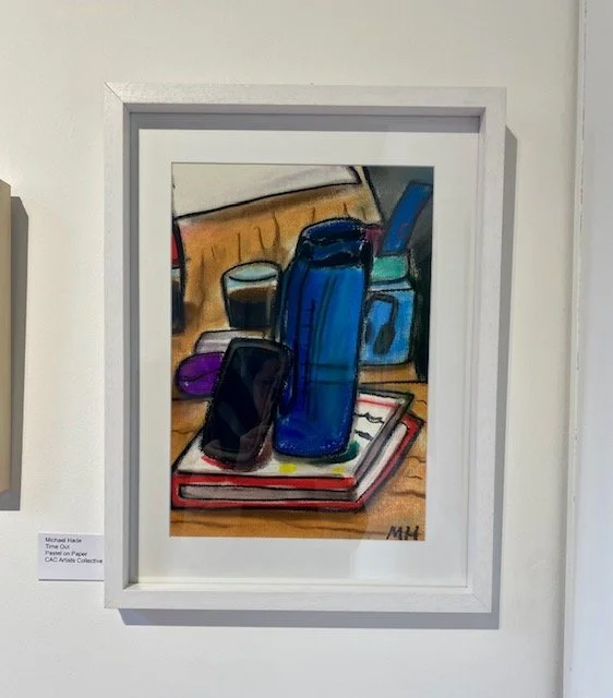 A framed pastel drawing of a still life arrangement featuring a blue water bottle and a smartphone resting on a book, with other objects and a wooden surface in the background.